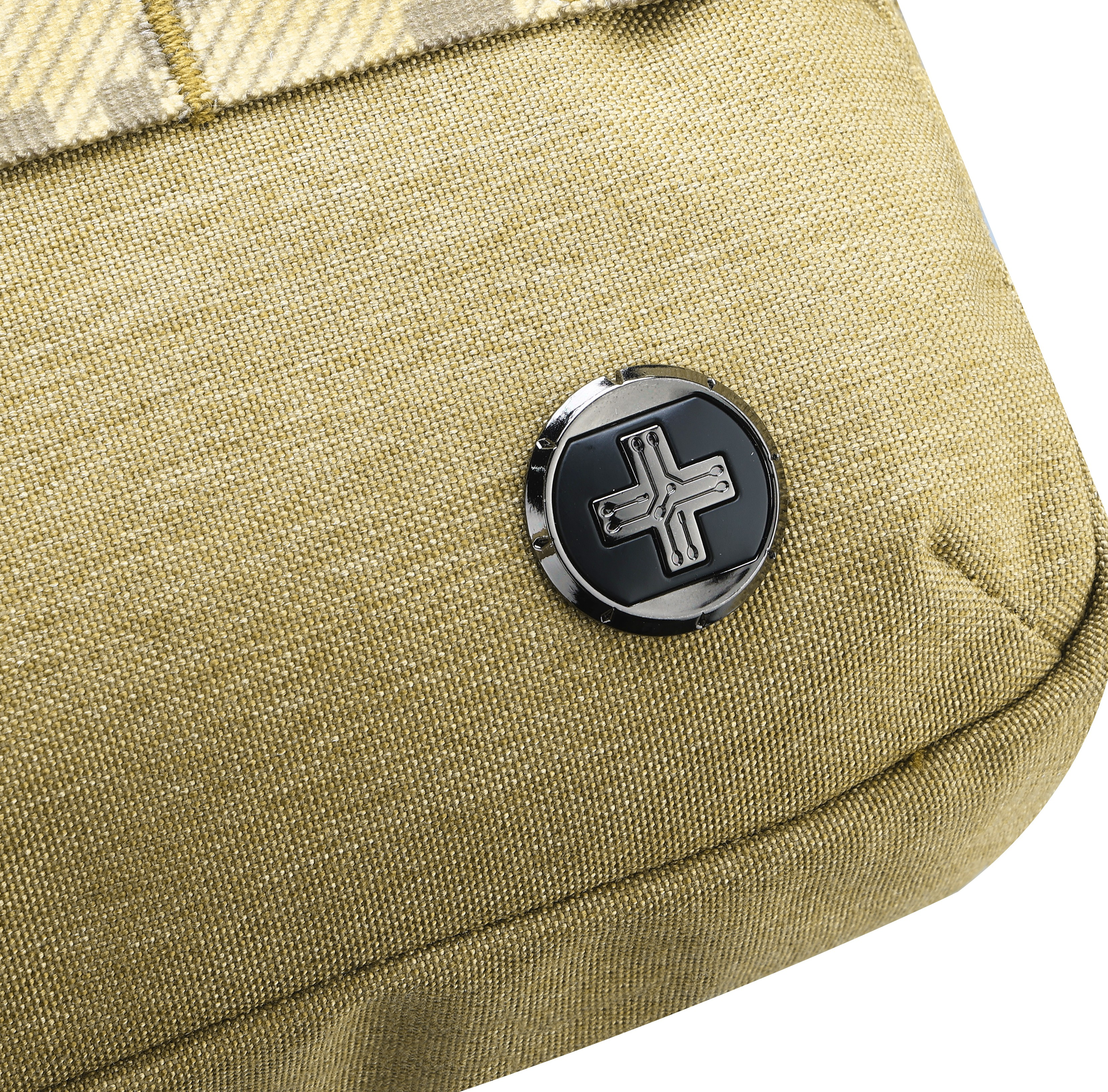 Primo piano di una borsa con un'emblema metallico. La borsa è beige. L'emblema è nero con una croce bianca.