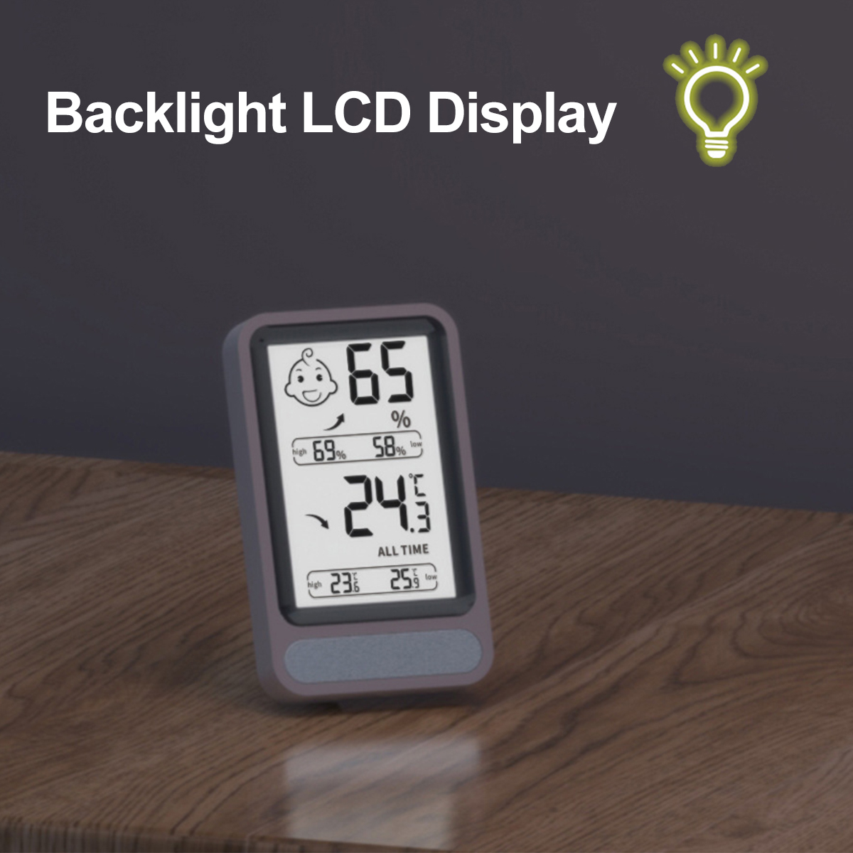 Ein Digitaldisplay zeigt Temperatur- und Feuchtigkeitswerte an. Es hat ein Babygesicht-Symbol und Hintergrundbeleuchtung. Das Gerät steht auf Holz.