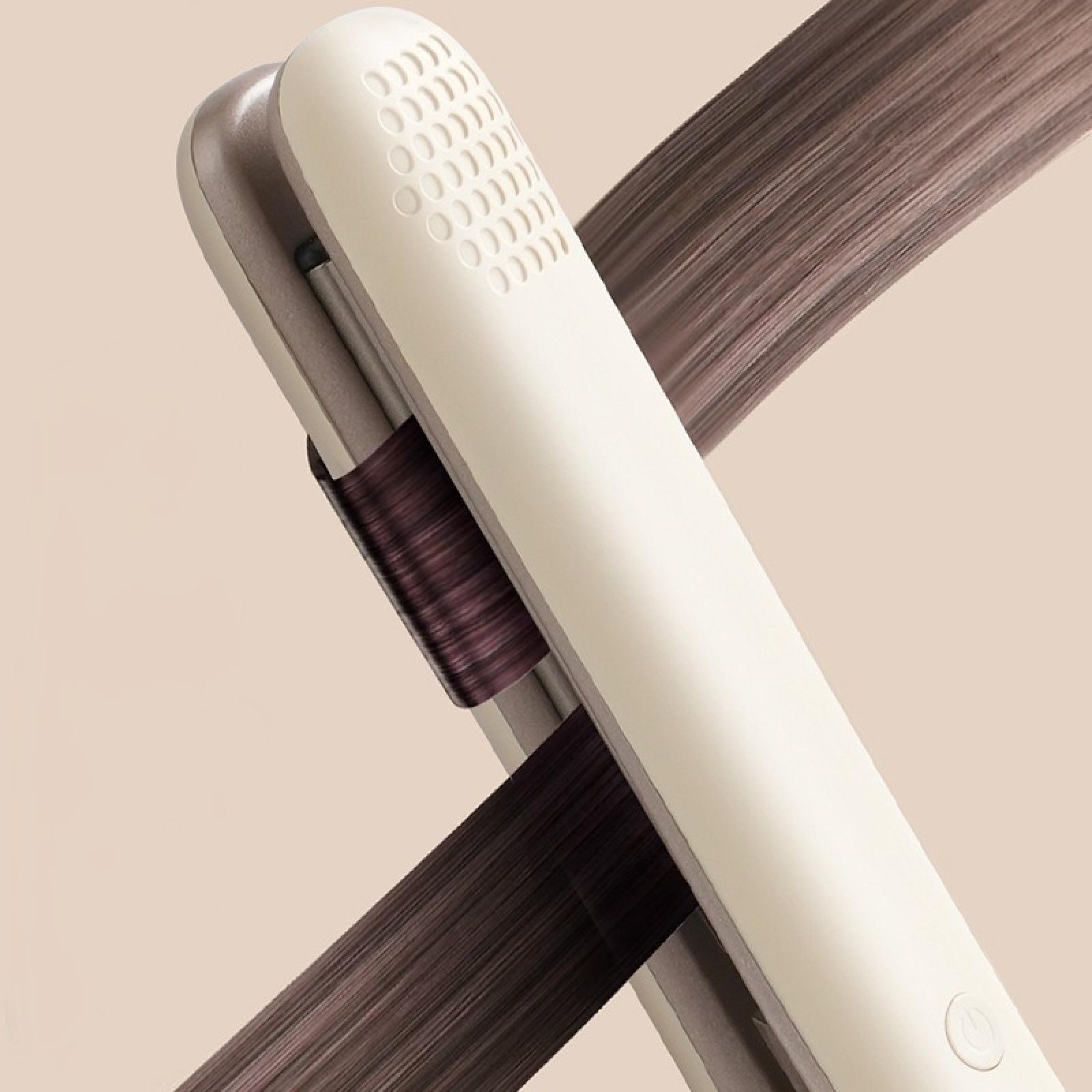 Ein Glätteisen mit Haarsträhnen. Das Eisen ist weiß und silber. Das Haar ist braun und fließt. Der Hintergrund ist beige.