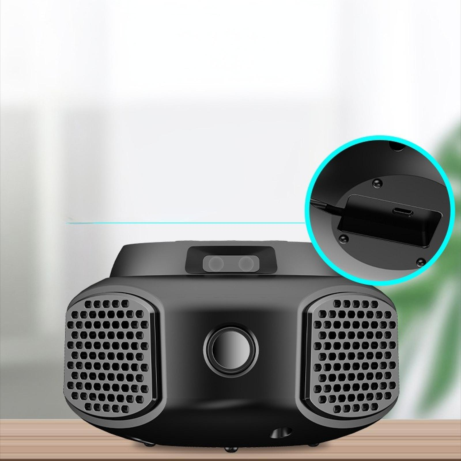 Ein schwarzes Gerät mit Lautsprecher-ähnlichem Design. Es hat mehrere Löcher, einen zentralen Knopf und einen USB-Anschluss.