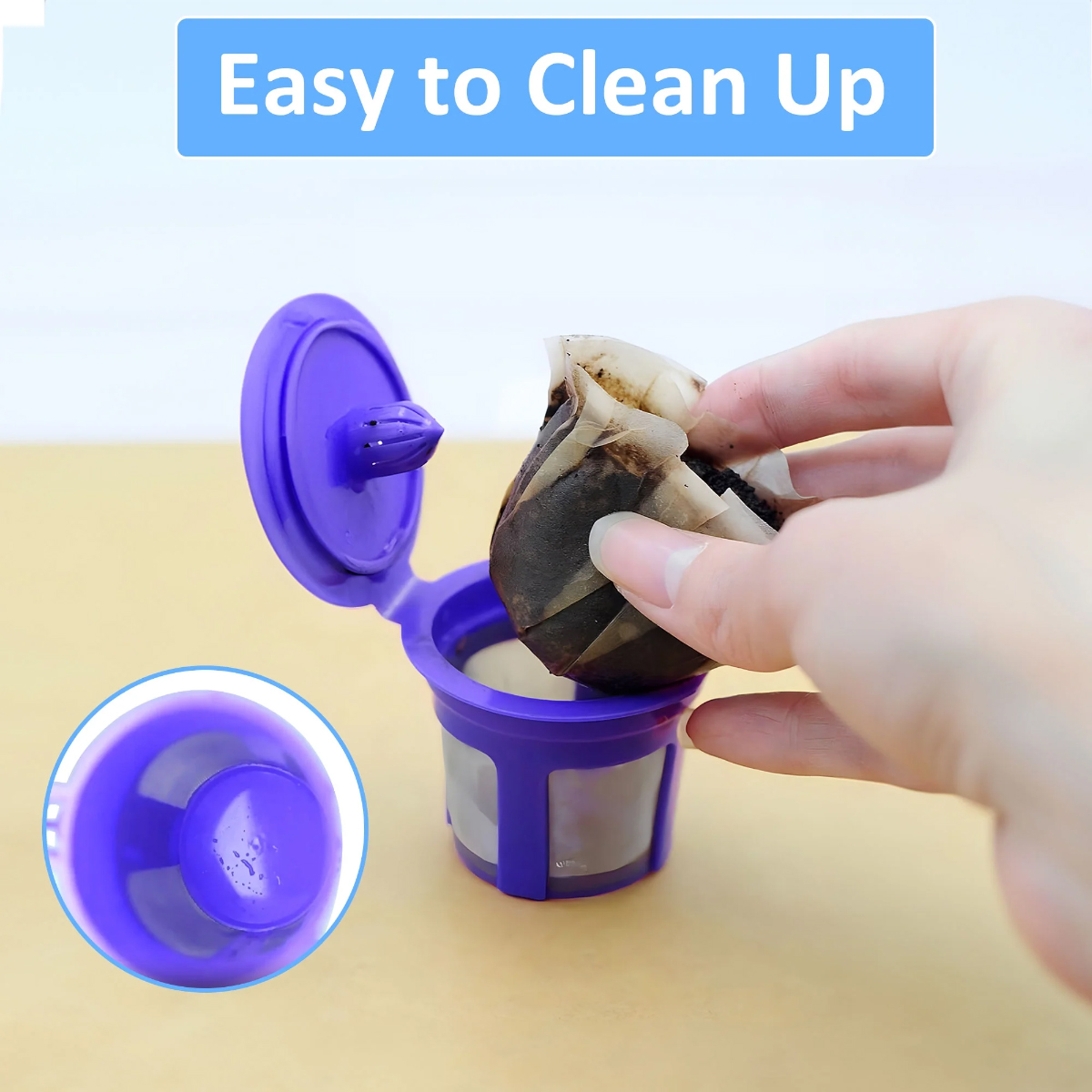 Eine Hand entfernt eine gebrauchte Kaffeekapsel aus einem lila Filter. Der Filter ist offen, darüber steht in blauem Text 'Easy to Clean Up'.