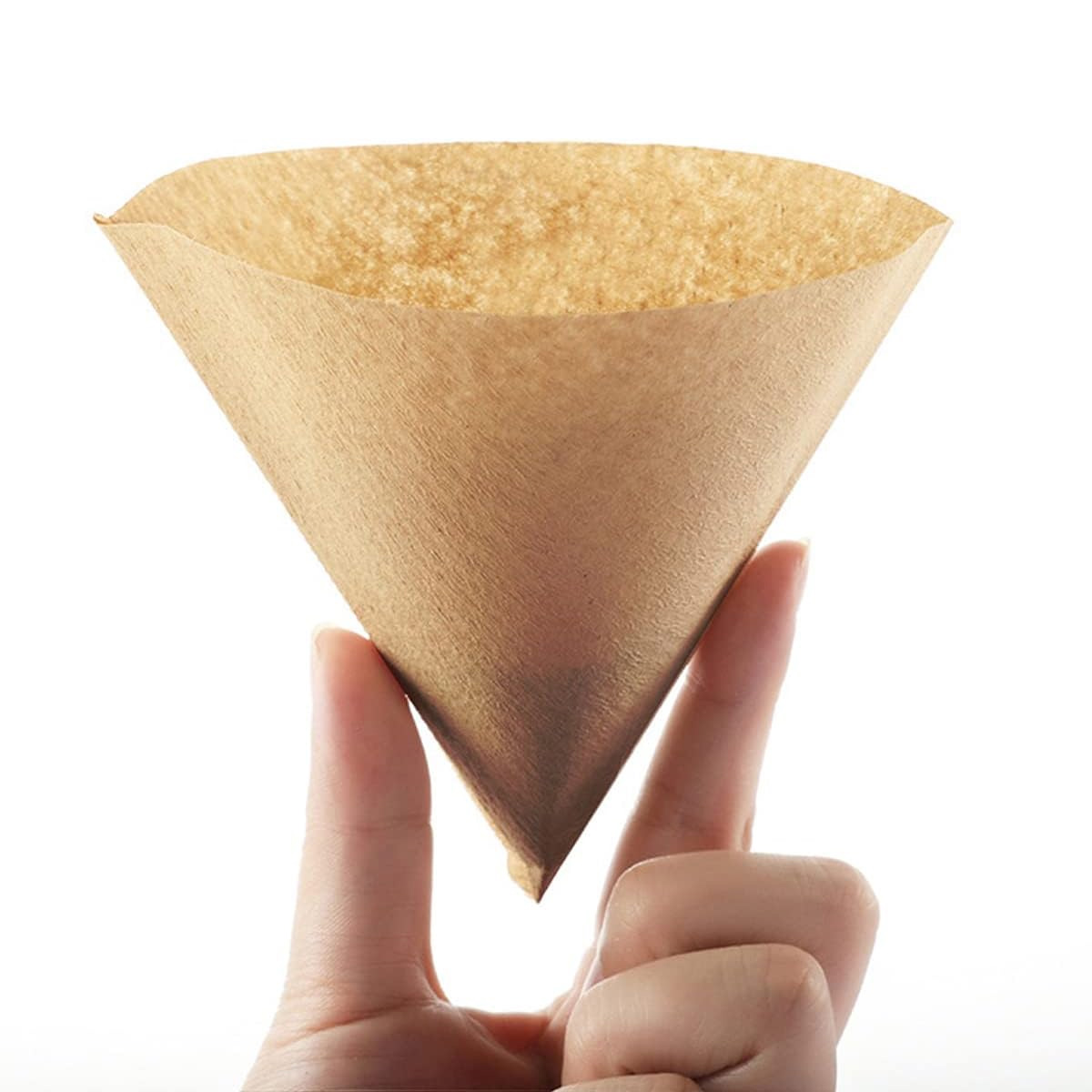 Eine Hand hält einen braunen Papier-Kaffeefilter vor weißem Hintergrund. Der Filter ist kegelförmig und leer.