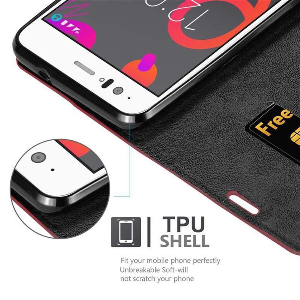 Uno smartphone in una custodia nera con rifiniture rosse. Lo schermo mostra un'interfaccia colorata. Una carta di credito è visibile.