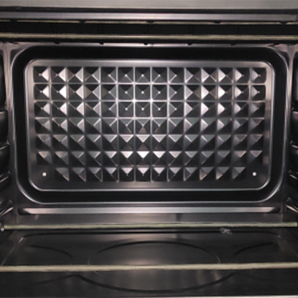 Interno di un forno argentato. La parete posteriore ha un motivo a forma di diamante. Una griglia è visibile in basso. Interno scuro.