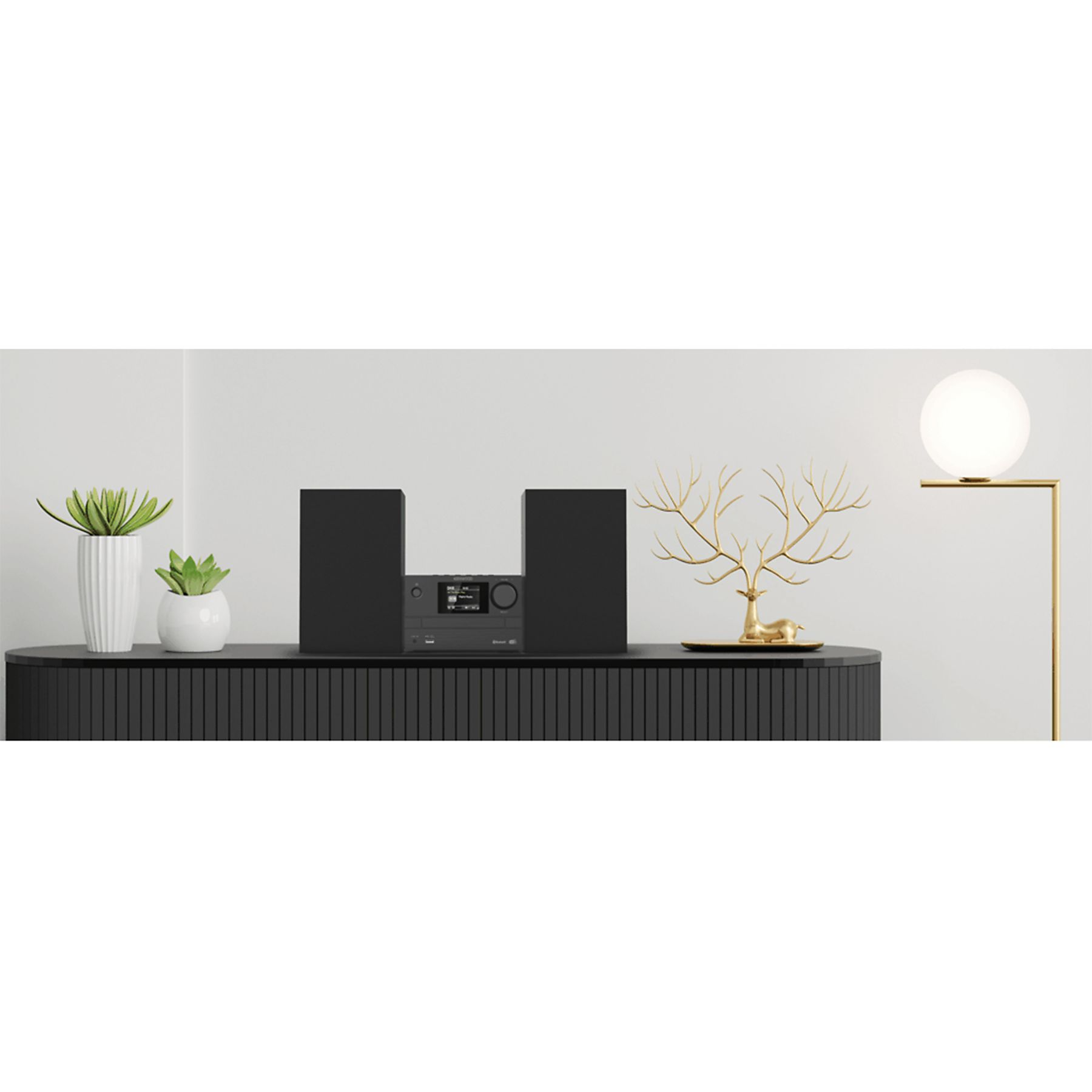 Una moderna unidad de entretenimiento negra con altavoces, un estéreo, plantas y objetos decorativos. Lámpara dorada a la derecha.