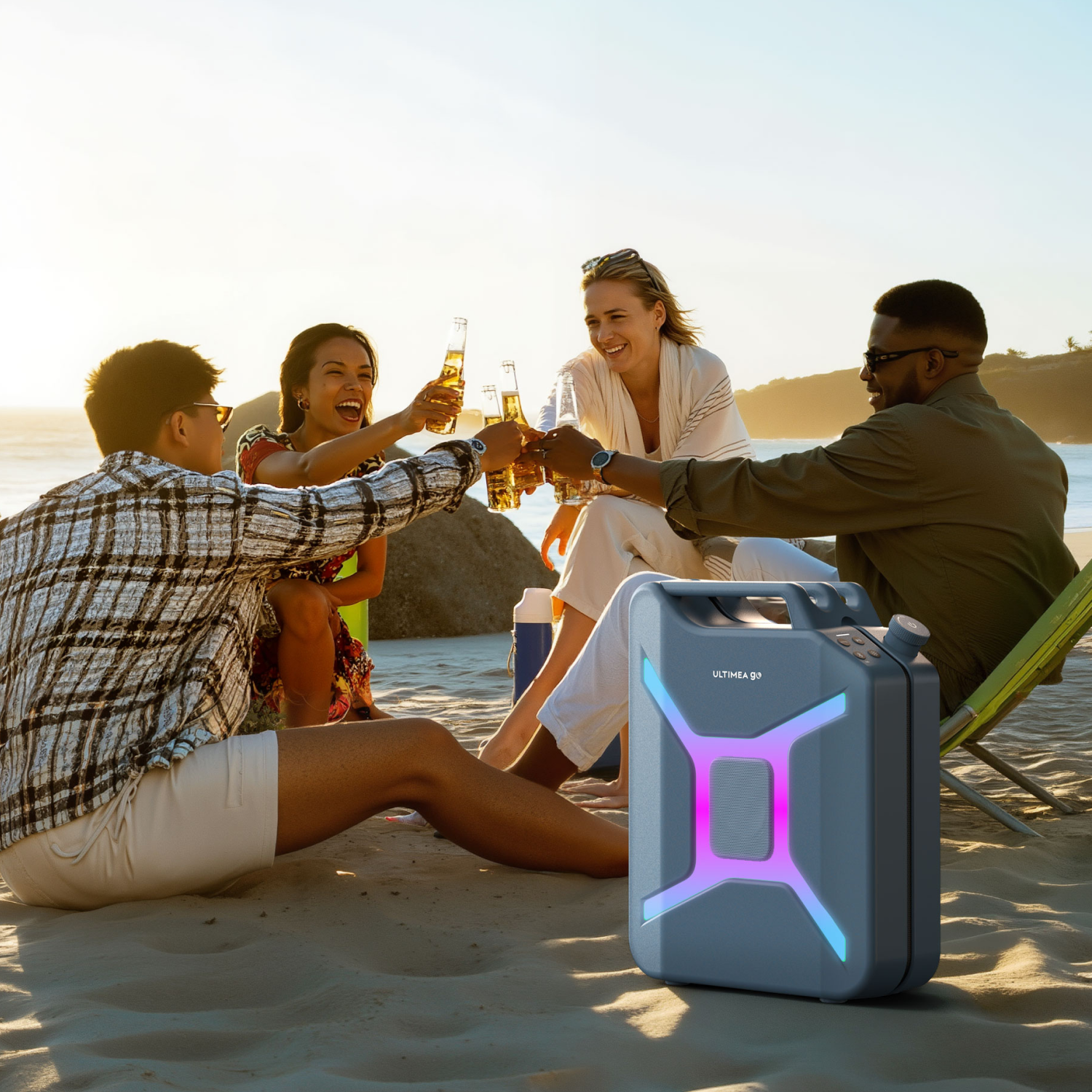 Vier mensen op het strand proosten met bier. Een grijze luidspreker staat op de voorgrond. De oceaan en de zonsondergang zijn op de achtergrond.