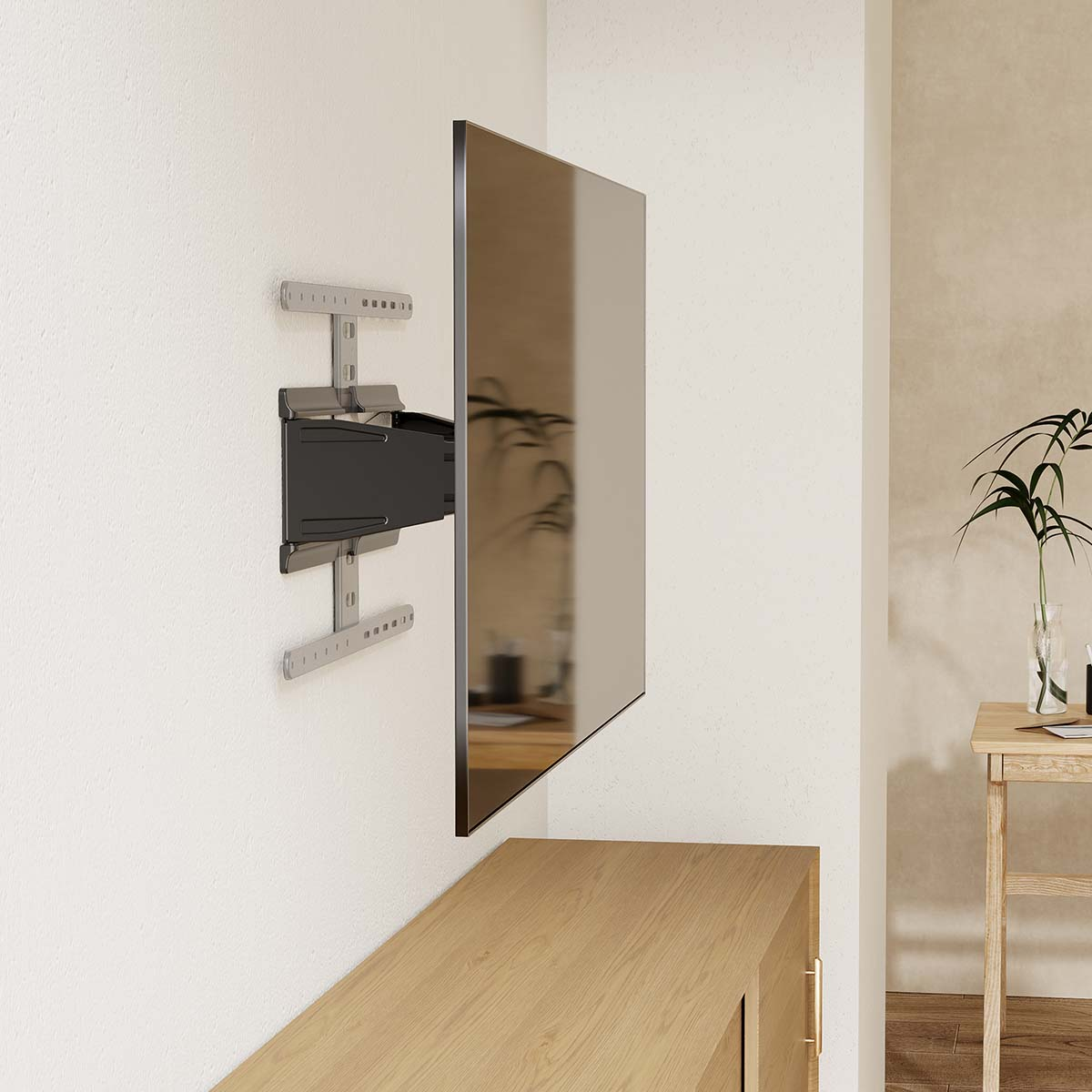 Ein Fernseher ist an einer weißen Wand montiert. Unter dem Fernseher befindet sich ein Holzschrank. Rechts steht ein Tisch mit einer Pflanze.