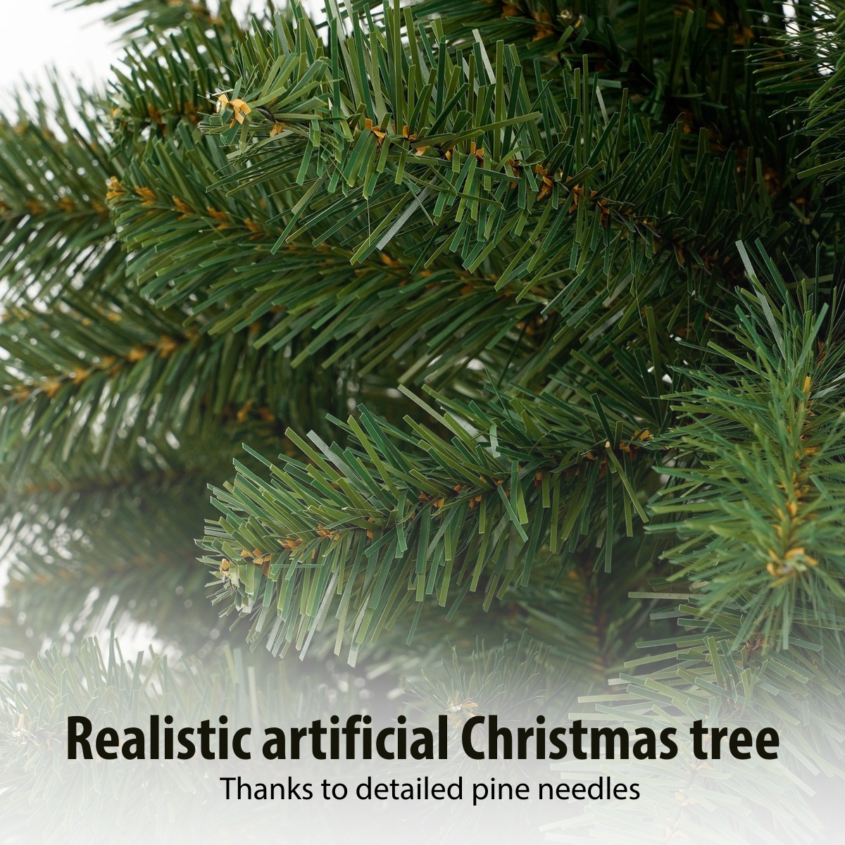 Gros plan sur un sapin de Noël artificiel réaliste. Les aiguilles vertes sont détaillées et denses. Le fond est flou et blanc.