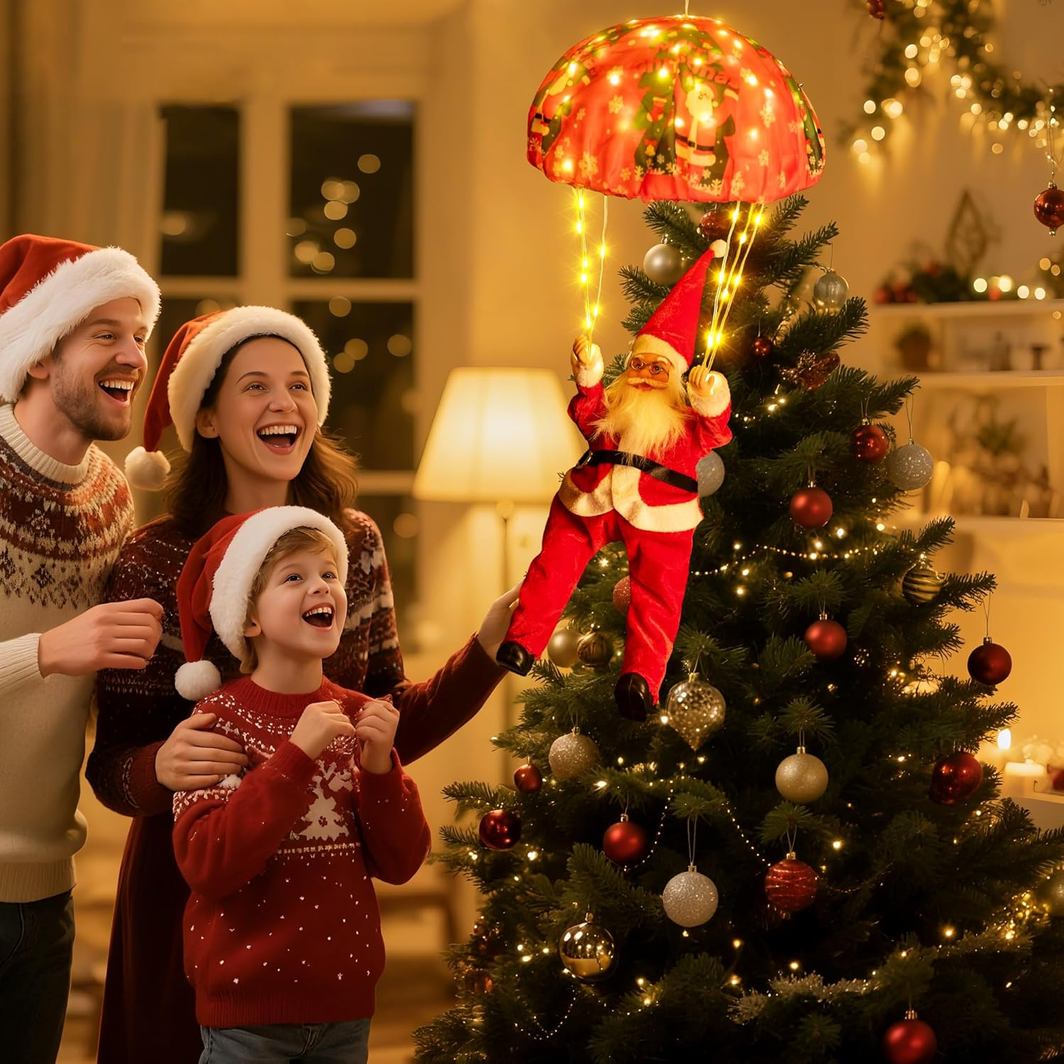 Eine Familie lacht über einen Weihnachtsmann-Ornament, der von oben über einen Weihnachtsbaum mit Ornamenten und Lichtern herabsteigt.