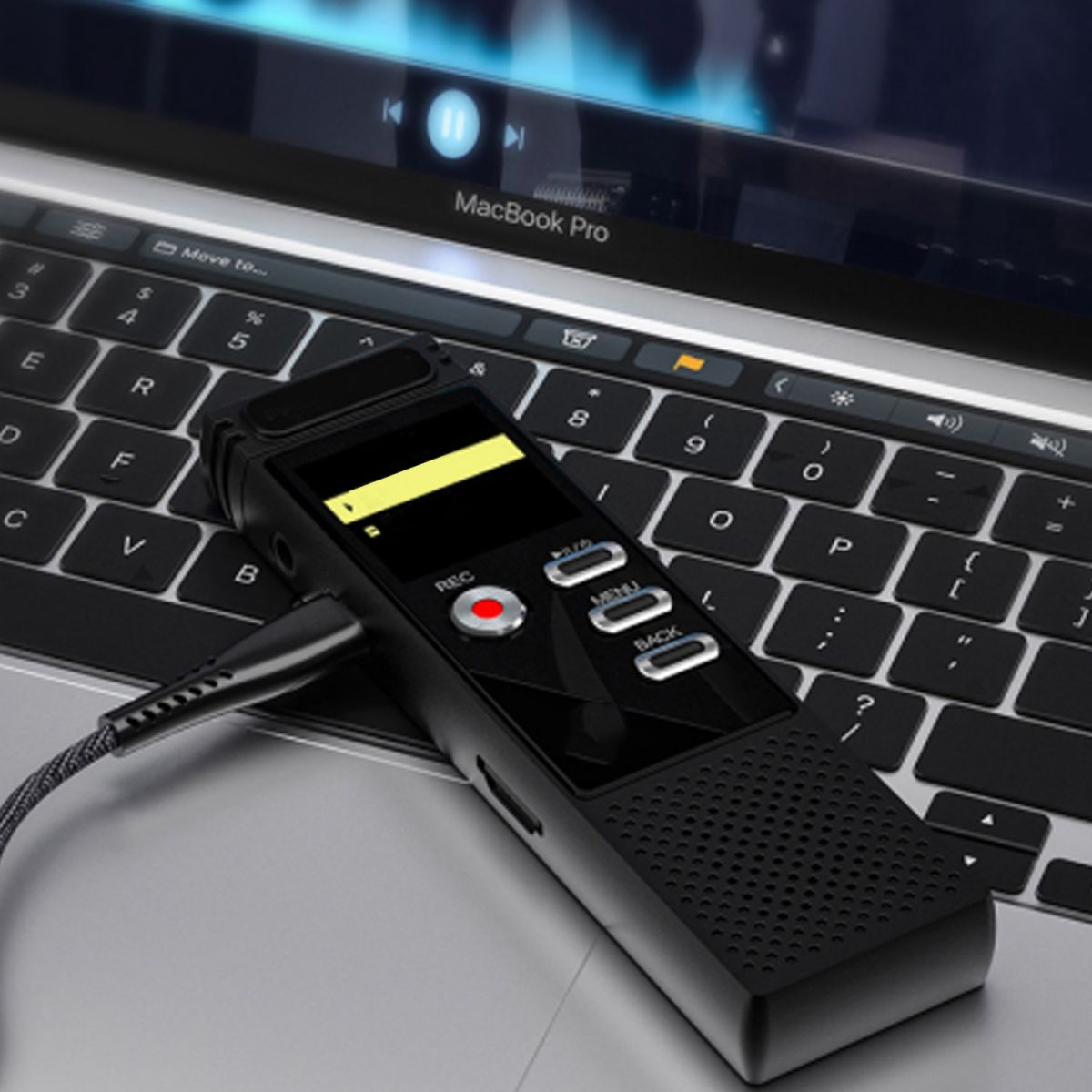 Ein schwarzes Aufnahmegerät liegt auf einer Laptop-Tastatur. Der Bildschirm zeigt ein Video. Das Gerät ist verkabelt.