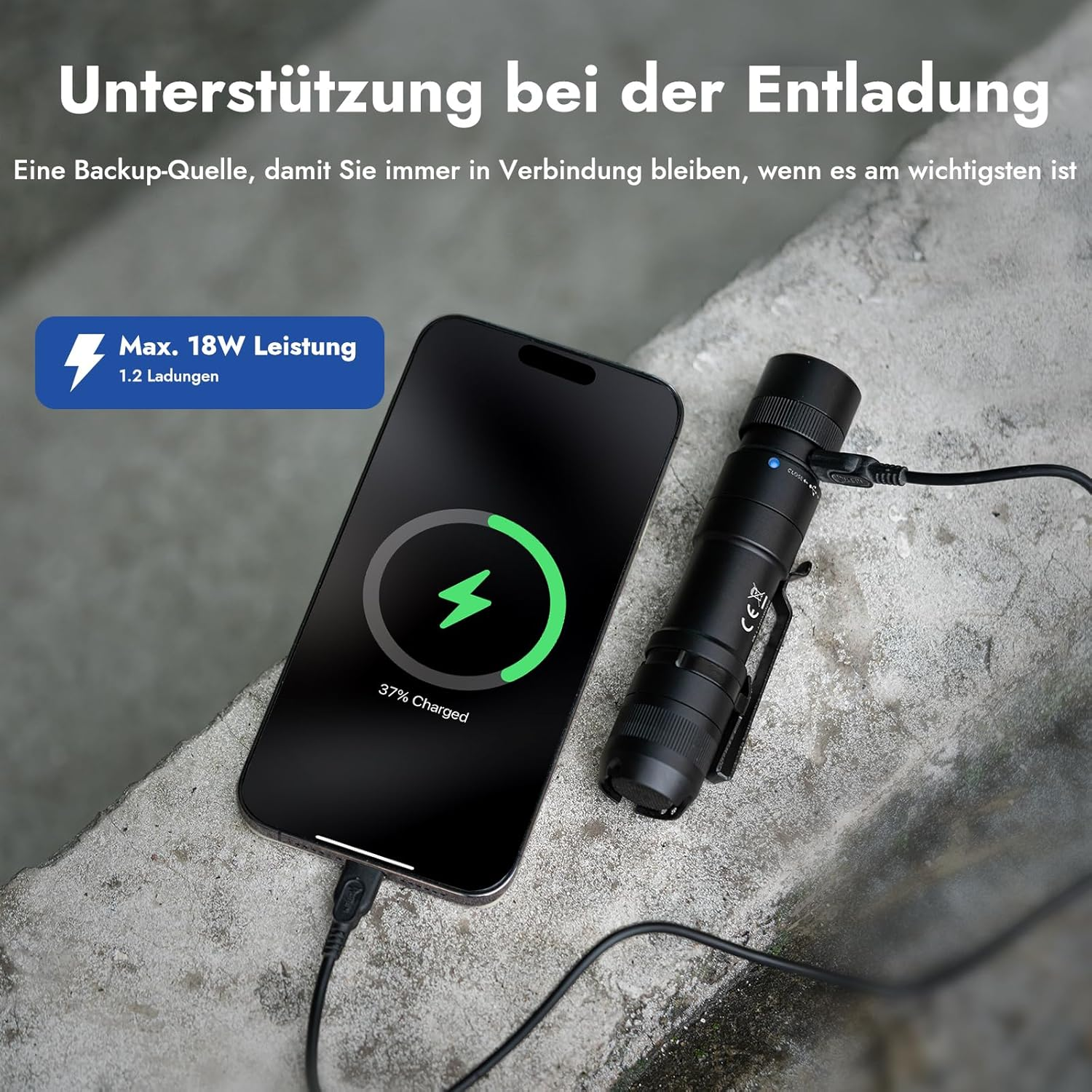 Ein Telefon, das von einem schwarzen, taschenlampenähnlichen Gerät aufgeladen wird. Auf dem Telefon wird 37 % geladen angezeigt.