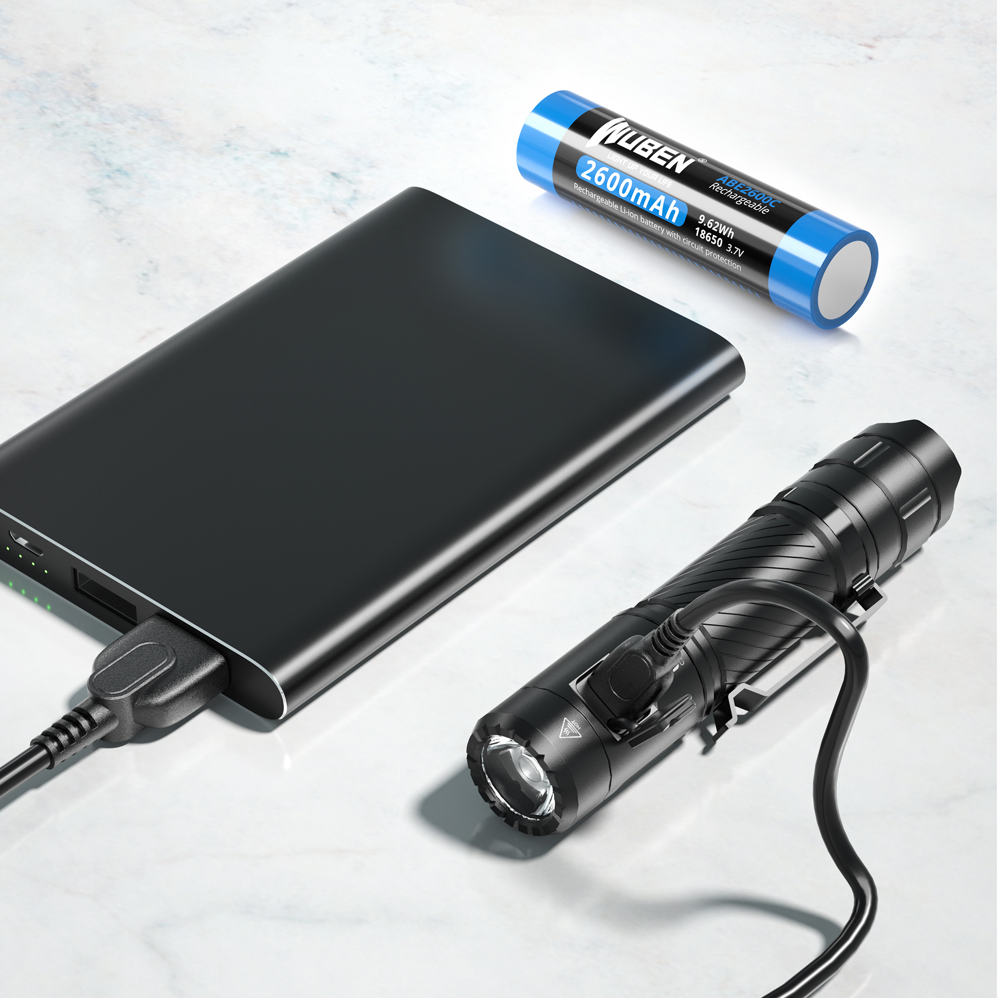 Schwarze Powerbank, Taschenlampe und Batterie auf Marmoroberfläche, alle mit Kabeln verbunden. Die Batterie ist blau.