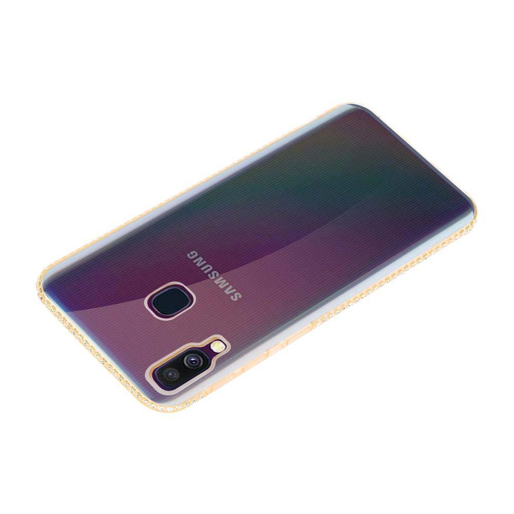 Ein Samsung-Telefon, abgewinkelt, mit einer durchsichtigen Hülle. Die Hülle hat einen goldenen Rand mit kleinen Details. Das Telefon hat eine Kamera und einen Blitz.
