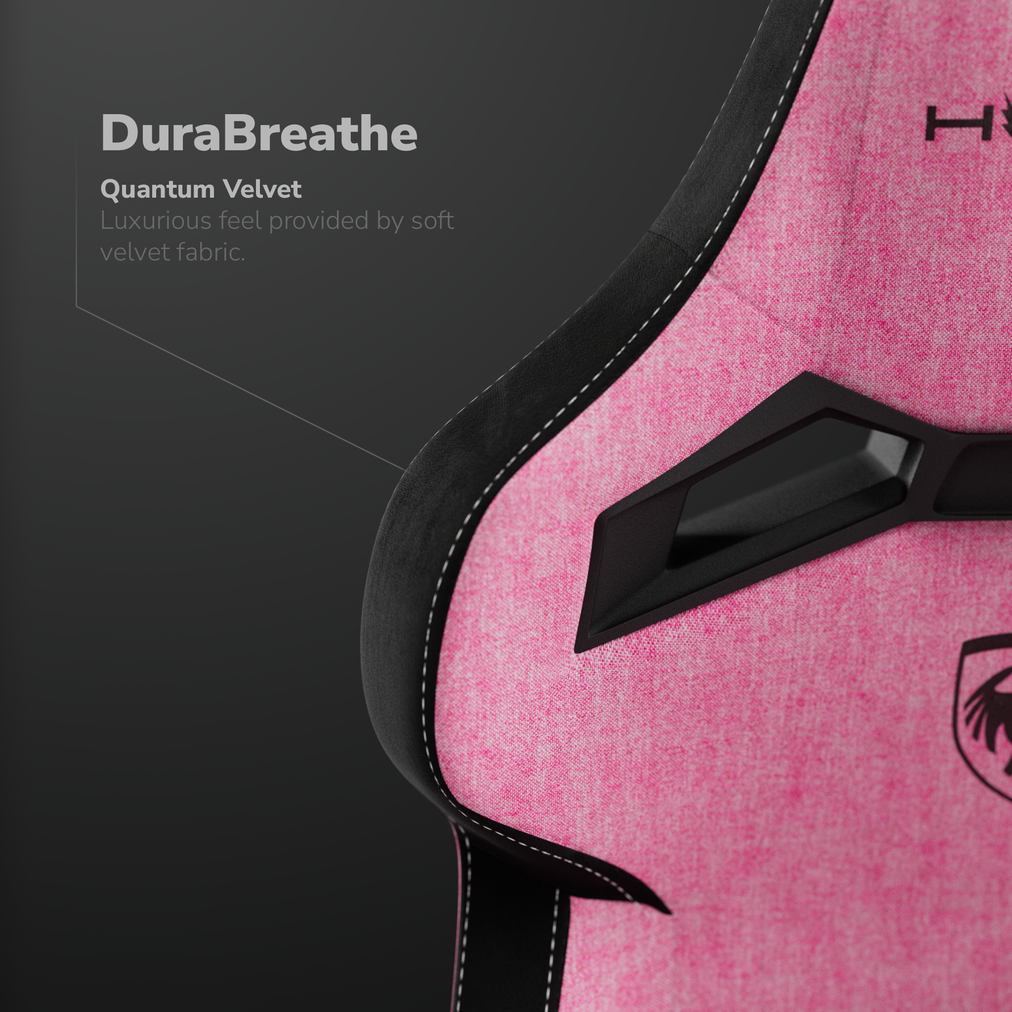 Gros plan sur une chaise de jeu rose avec des accents noirs. Logo et texte noirs visibles. Le tissu est Quantum Velvet.