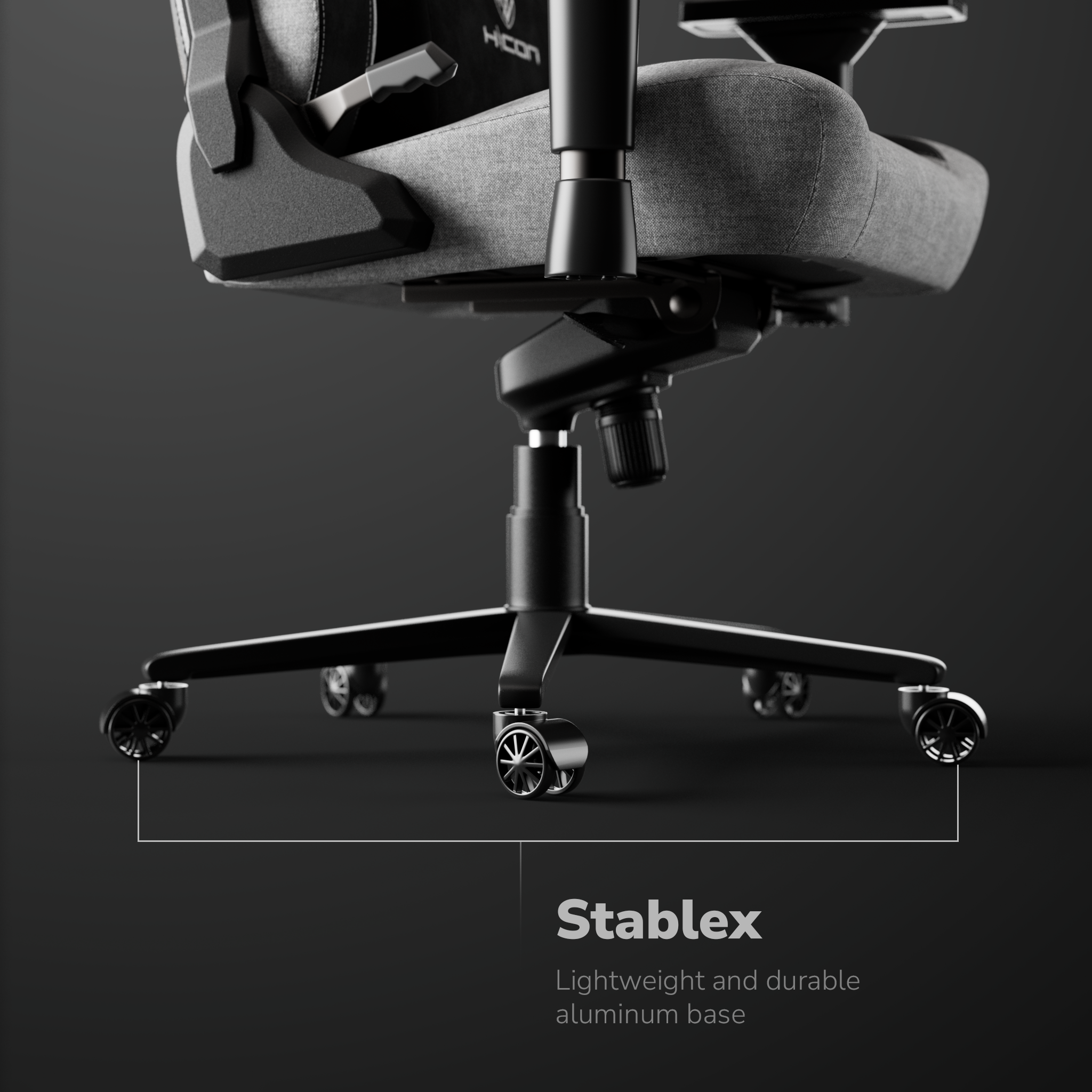 Dettaglio sedia gaming. Sedile e schienale grigi, telaio nero. Testo 'Stablex', base in alluminio leggera e durevole.