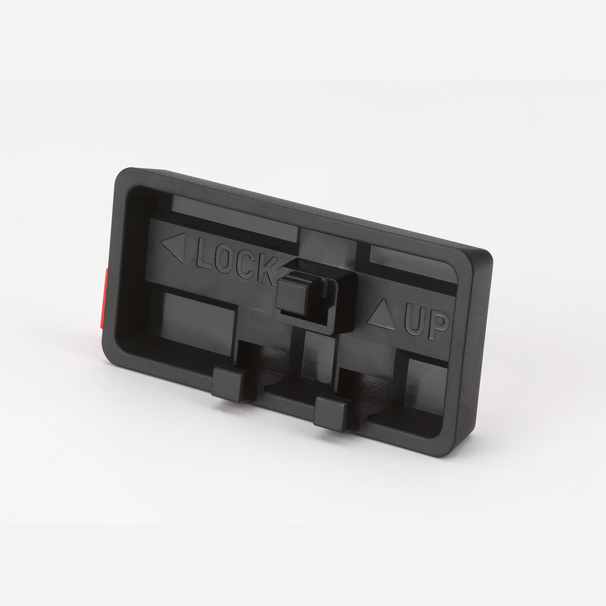 A black plastic part with 'LOCK' and 'UP' labels. A red tab is visible on the left side, with a white background.