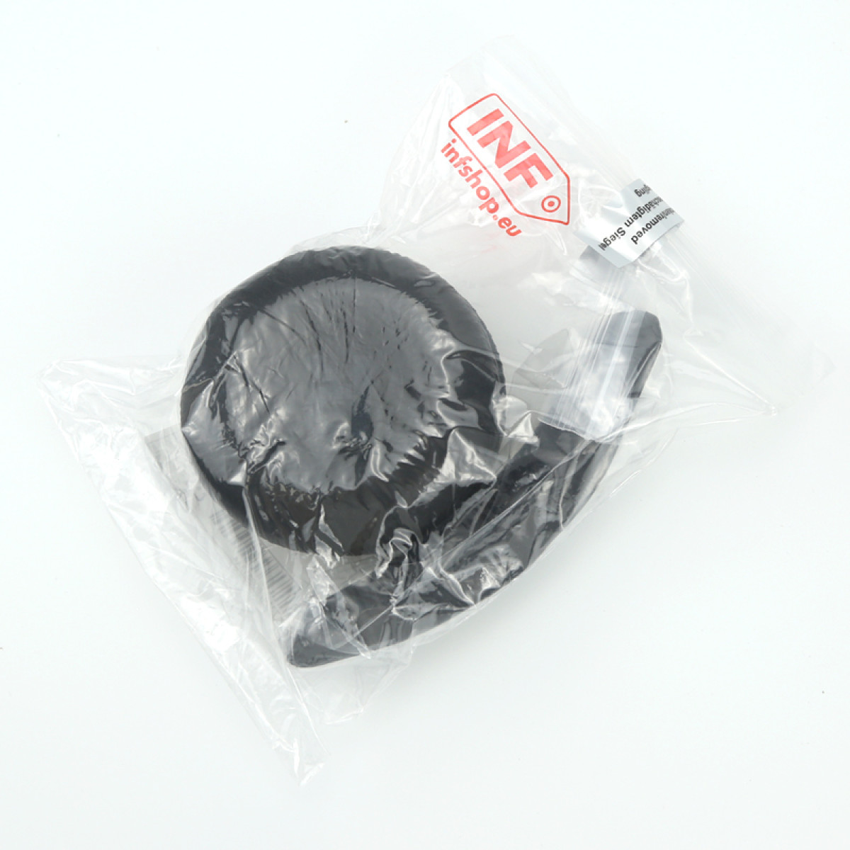 Un oggetto nero, forse una ruota, è sigillato in un sacchetto di plastica trasparente. La borsa ha un logo rosso e bianco.