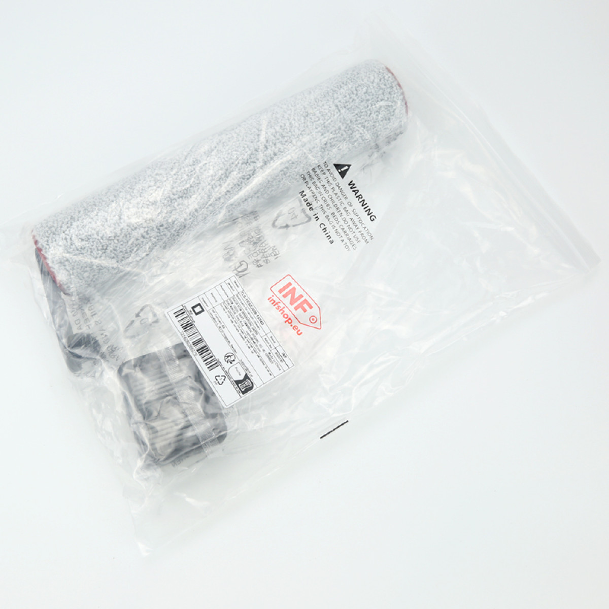 Un rodillo y accesorios sellados en una bolsa de plástico transparente. La bolsa tiene una etiqueta de advertencia e información del producto.