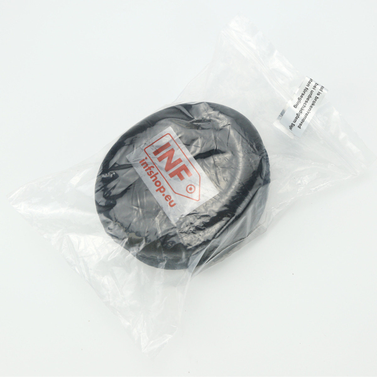 Ein schwarzes Gummiteil in einer durchsichtigen Plastiktüte, mit einem Etikett mit der Aufschrift INF infshop.eu.