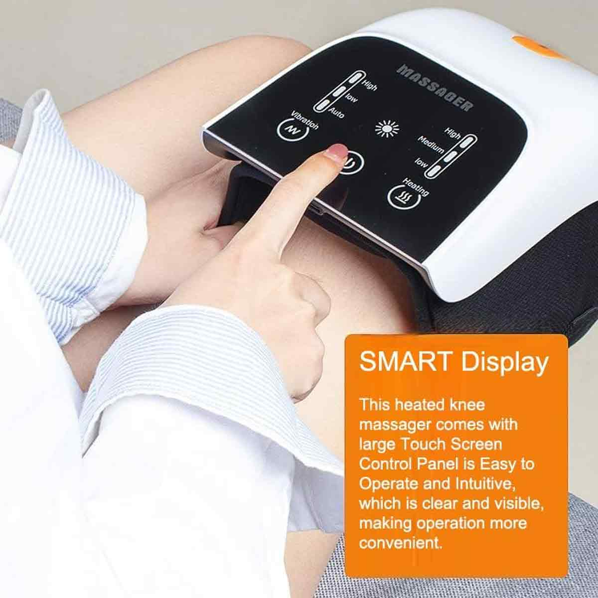 Eine Hand drückt auf eine Taste eines Kniemassagegeräts. Das Gerät hat ein digitales Display mit Bedienoptionen und dem Wort "MASSAGER".