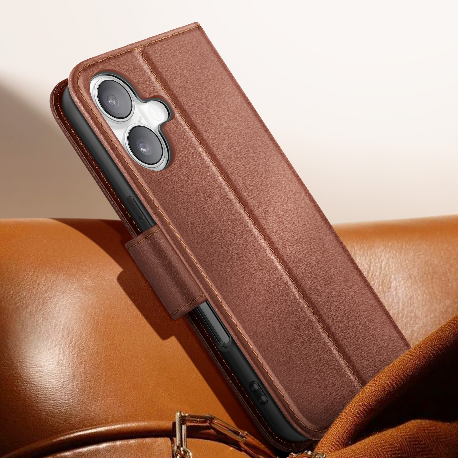 Custodia per telefono in pelle marrone con telefono all'interno. La custodia è su una superficie in pelle marrone.