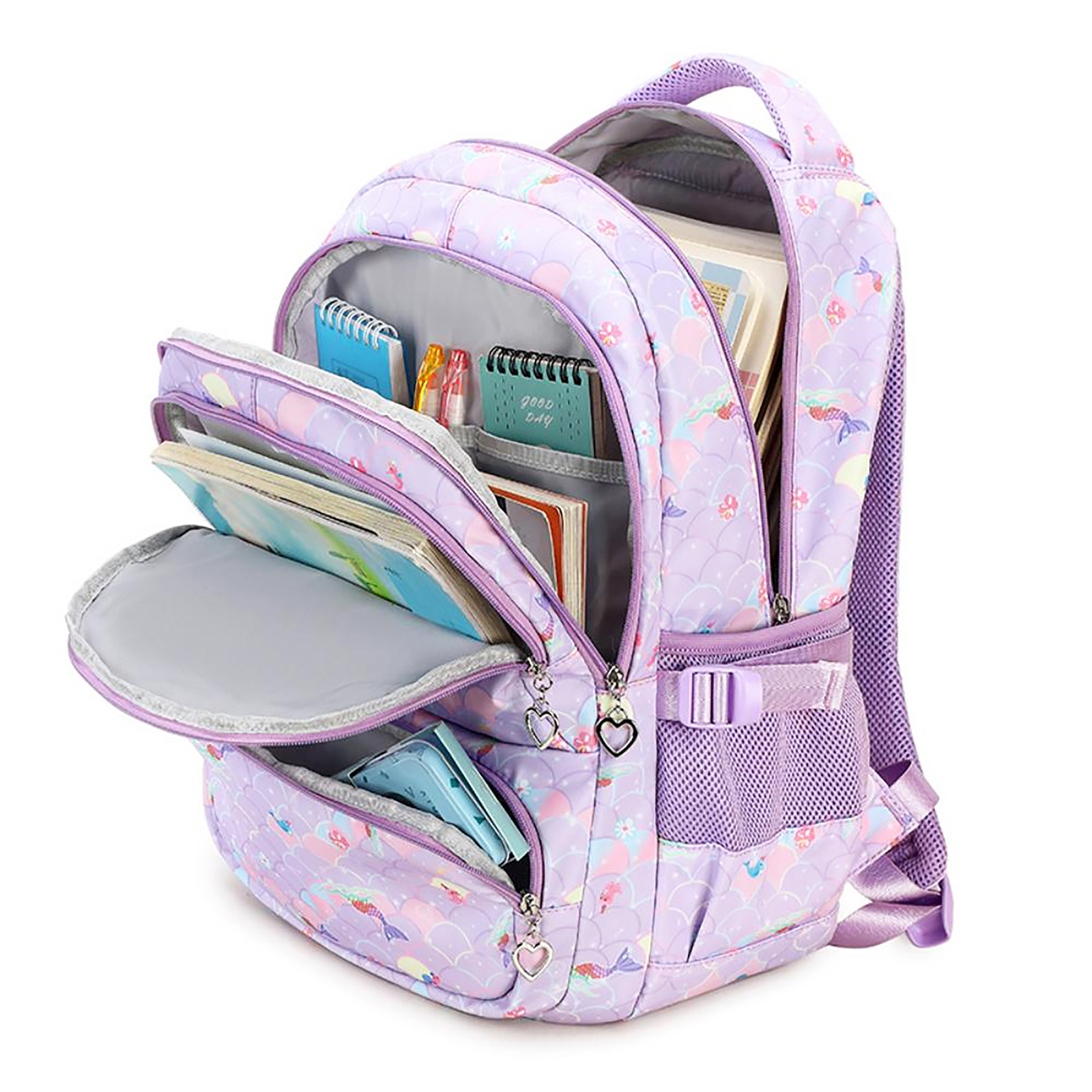 Lila Rucksack mit Meerjungfrauenmuster, offen, um Bücher und Schreibwaren zu zeigen. Herzförmige Reißverschlussanhänger.