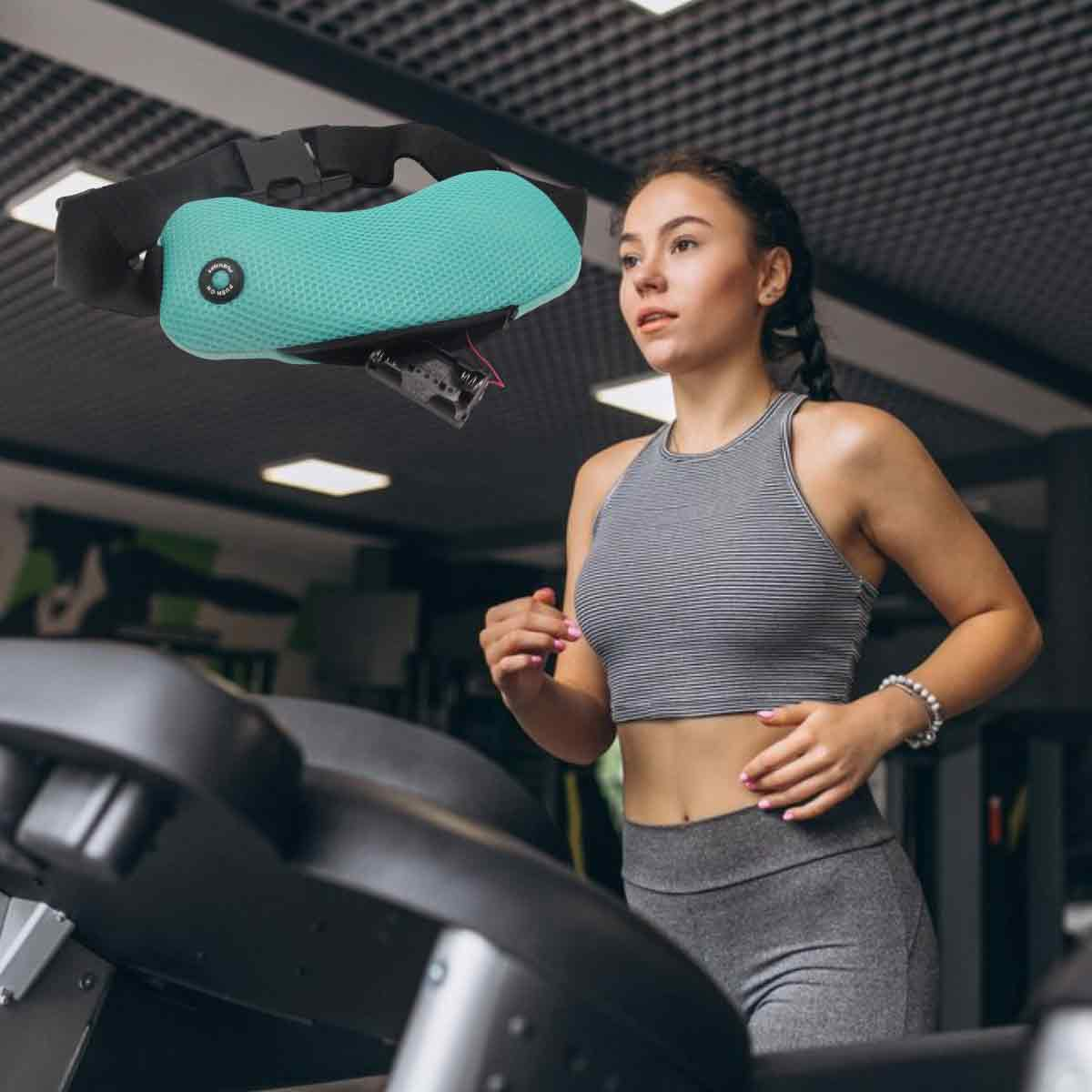 Frau läuft auf dem Laufband im Fitnessstudio, trägt graue Sportkleidung. Über ihr schwebt ein türkisfarbenes Gerät. Hintergrund: Fitnessgeräte.
