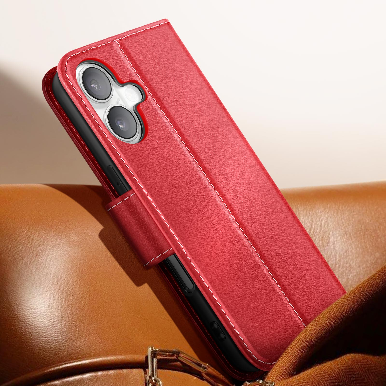 Custodia per telefono rossa, cucita con filo bianco, su sfondo marrone. Il telefono ha due lenti.
