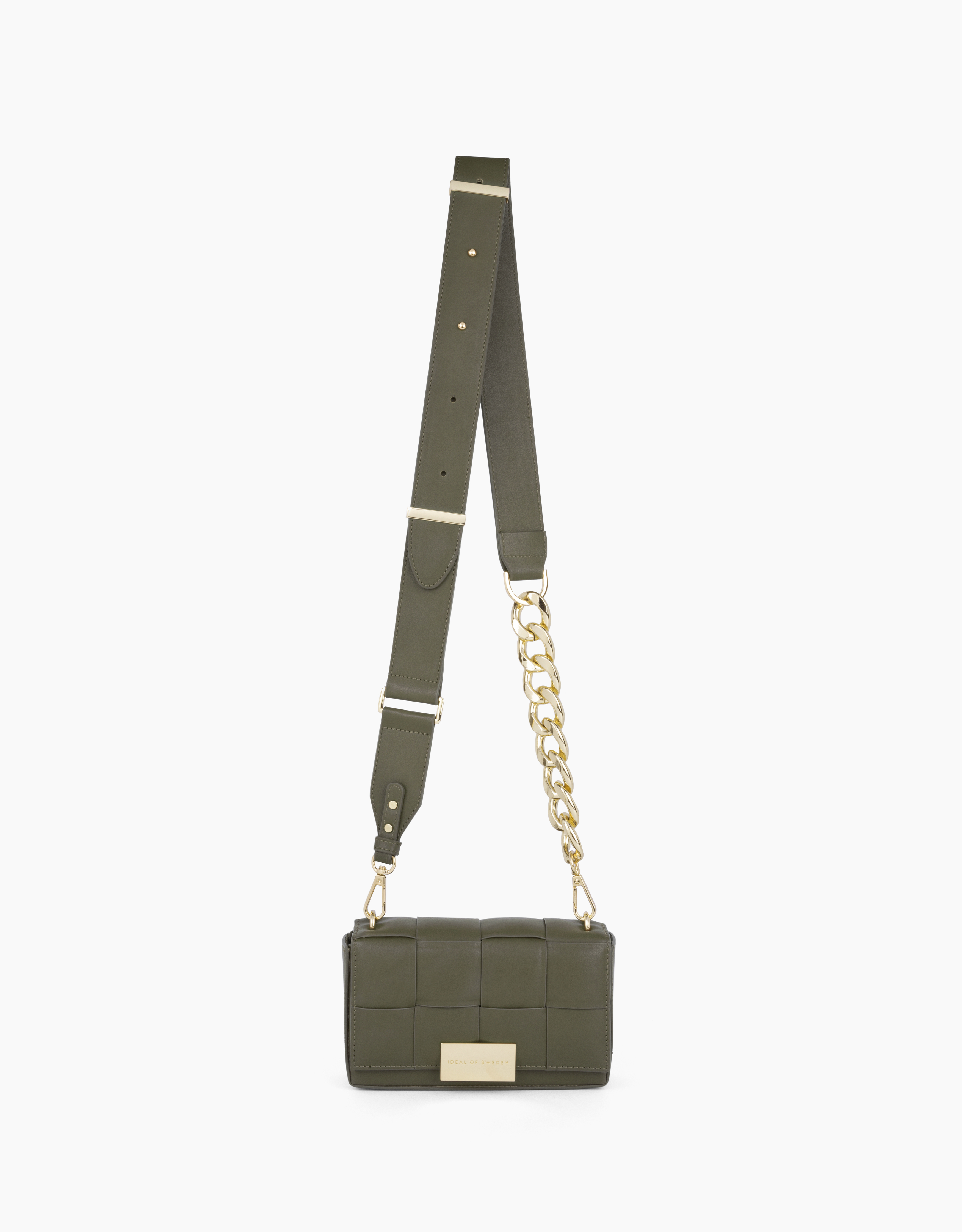 Eine olivgrüne Handtasche mit langem Riemen und goldenen Kettendetails hängt vor weißem Hintergrund.