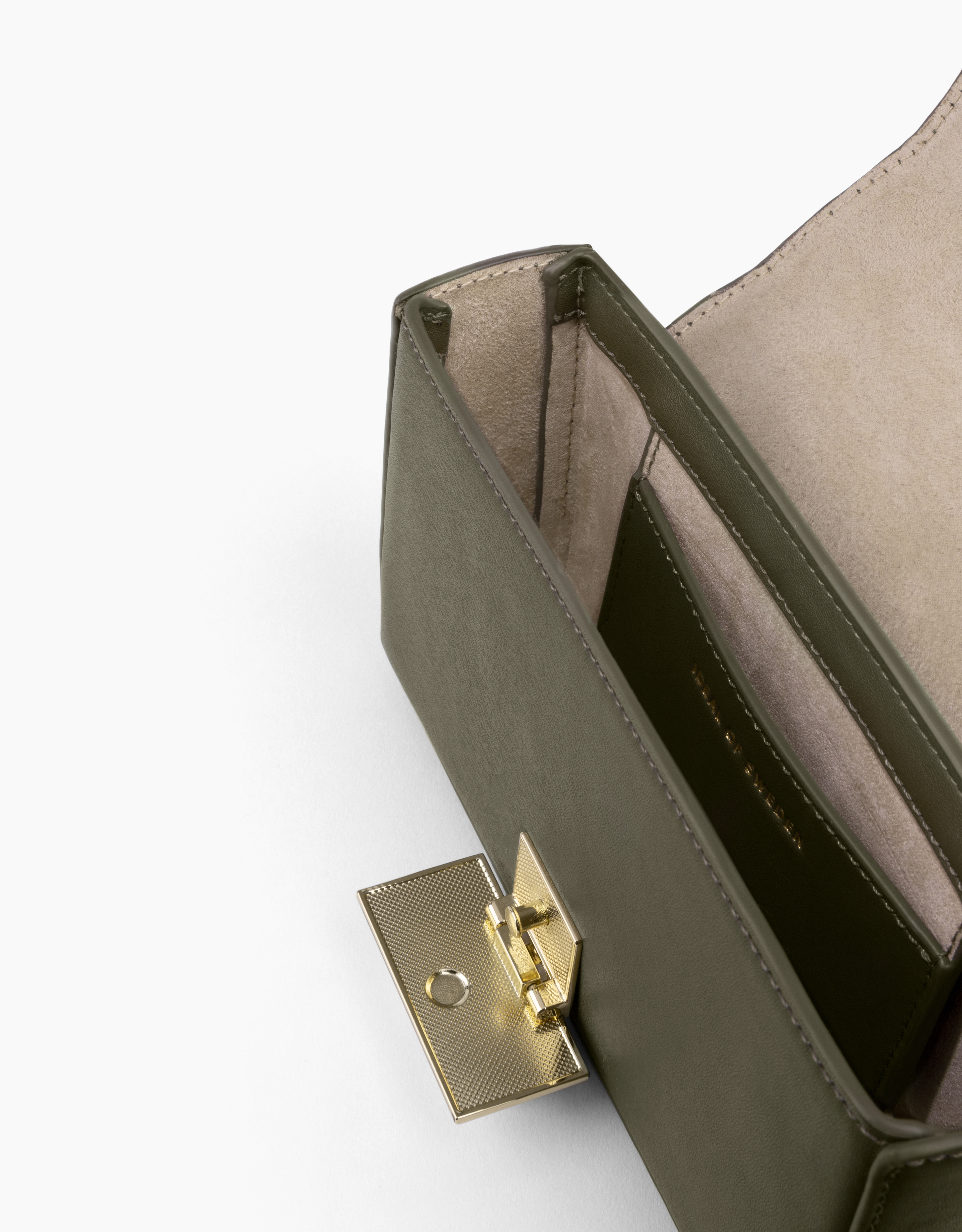 Offene olivgrüne Handtasche mit goldenem Verschluss. Der Innenraum ist beige. Weißer Hintergrund.