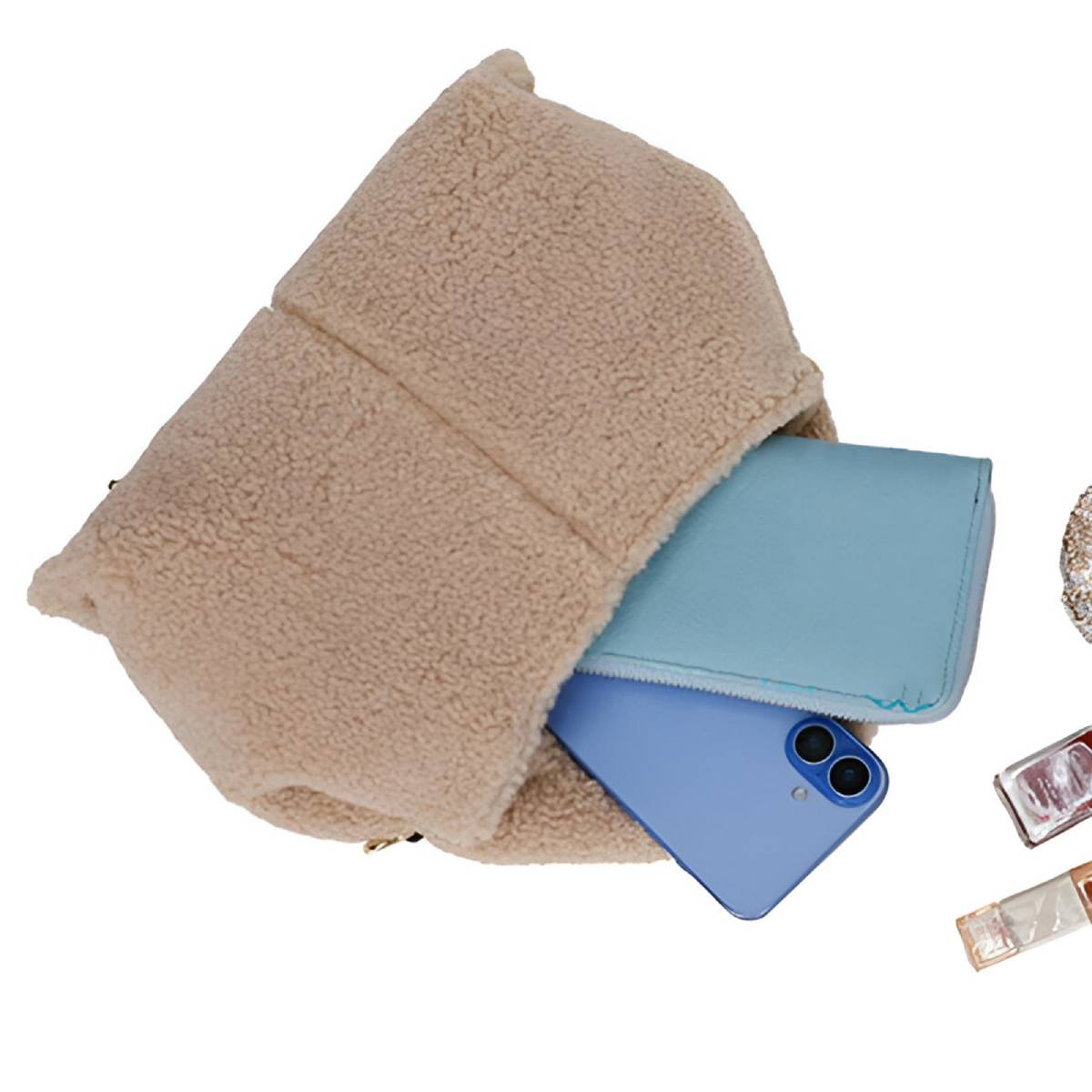 Una bolsa beige y esponjosa, una billetera azul claro y un teléfono azul son visibles. También se ven algunos artículos de maquillaje.