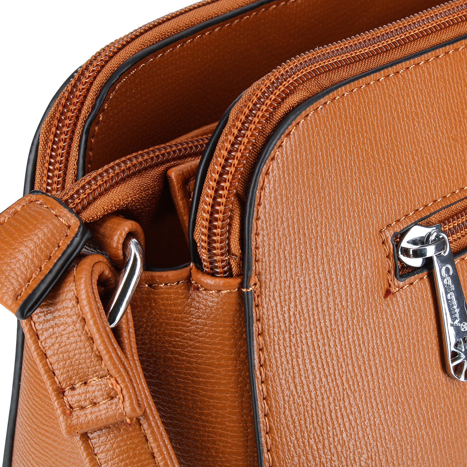 Primer plano de un bolso de cuero marrón con cremalleras, una correa y herrajes plateados. El bolso es texturizado.