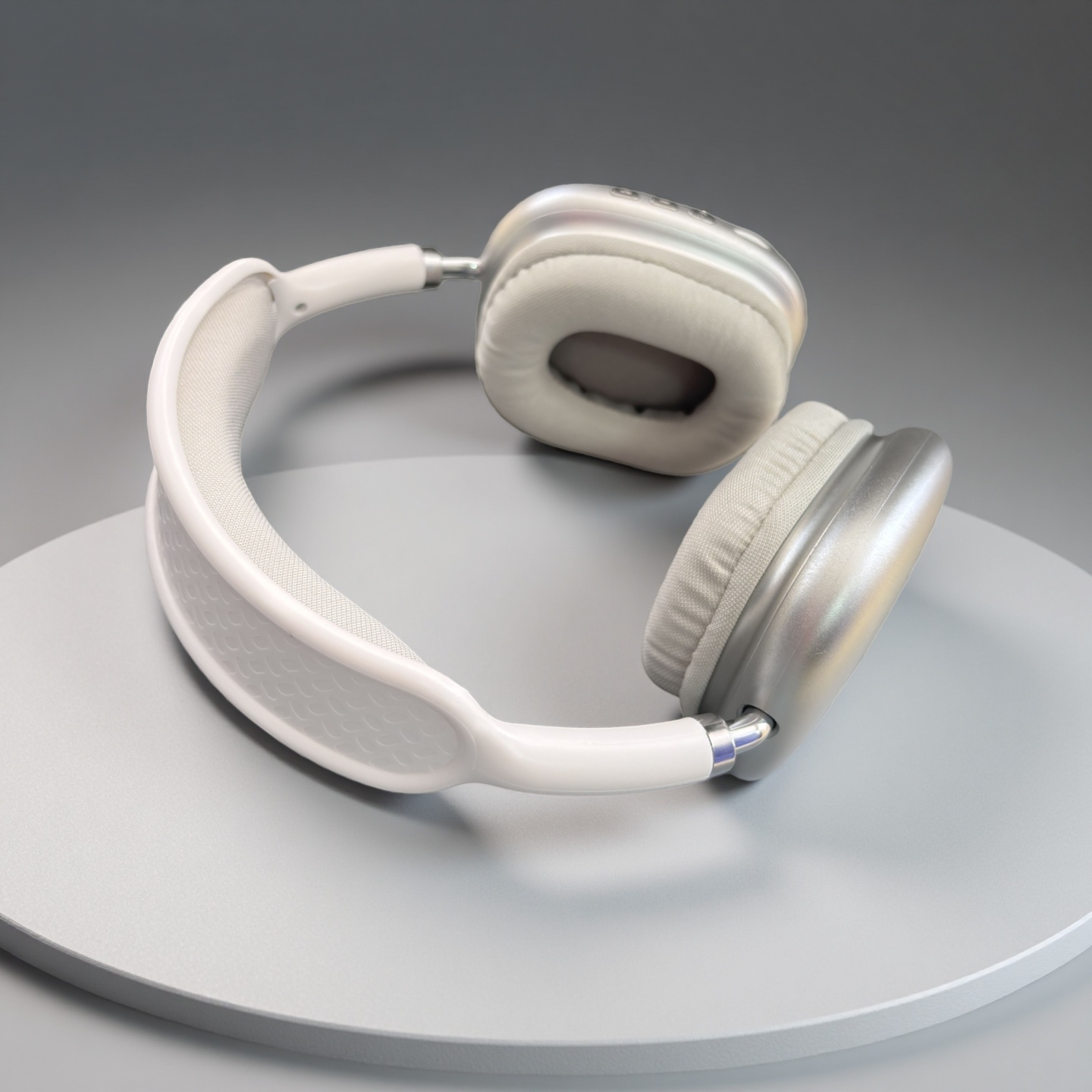 Auriculares blancos y plateados sobre una superficie gris. Los auriculares están tumbados. El fondo también es gris.