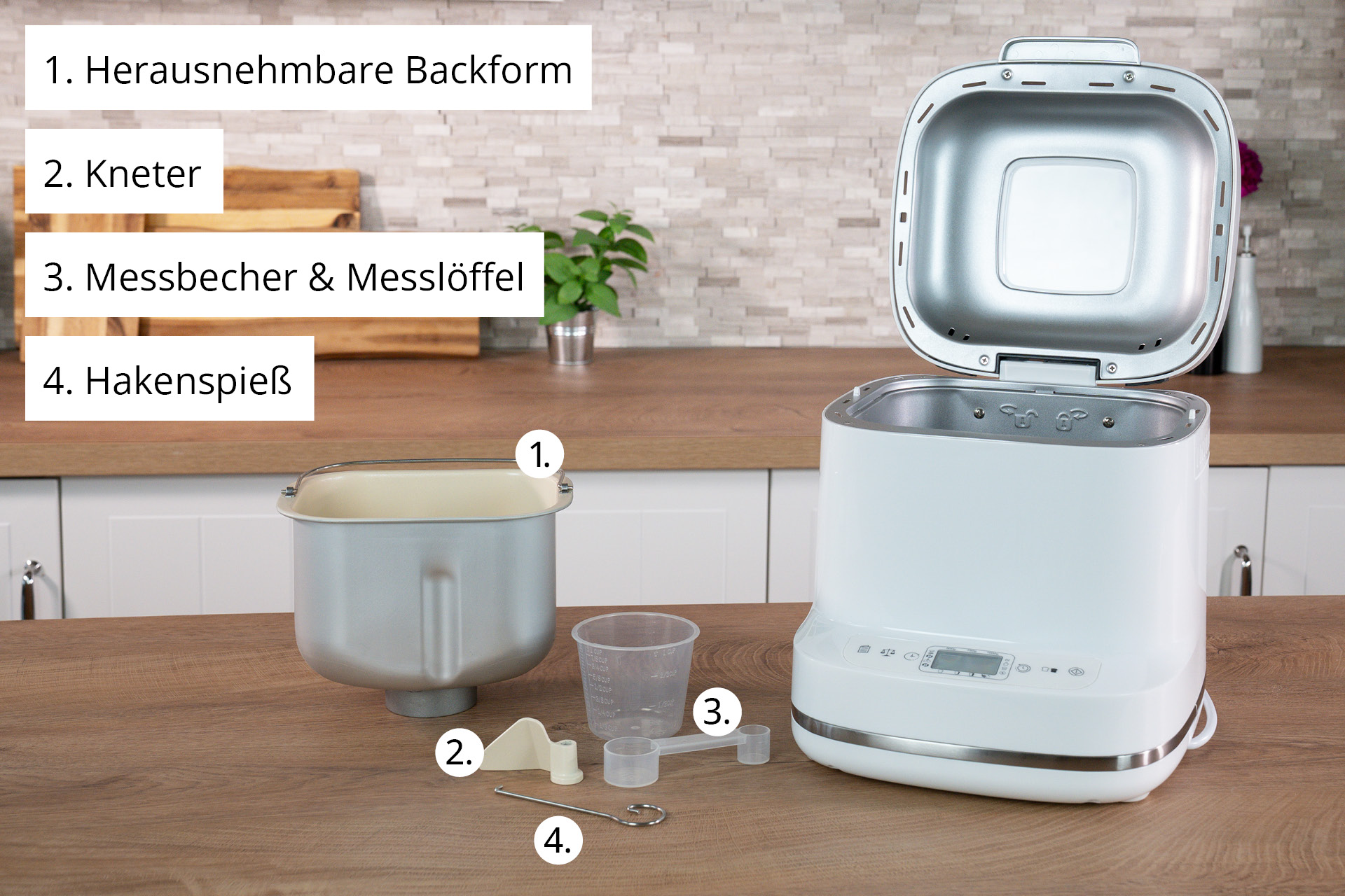 Ein weißer Brotbackautomat mit seinen Komponenten: Backform, Knethaken, Messbecher und Löffel sowie ein Haken.
