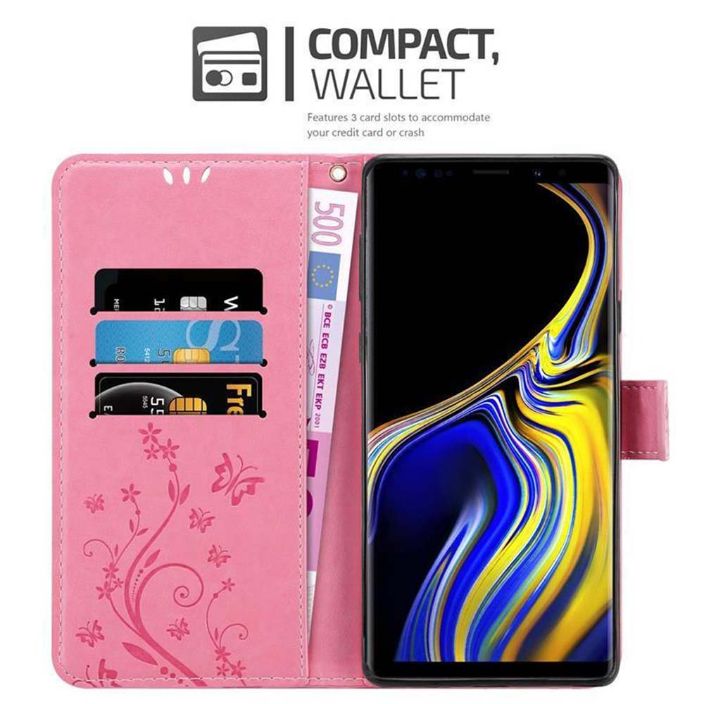 Portafoglio rosa con telefono, carte di credito e una banconota da 500 euro. Il portafoglio ha disegni floreali e il telefono è nero.