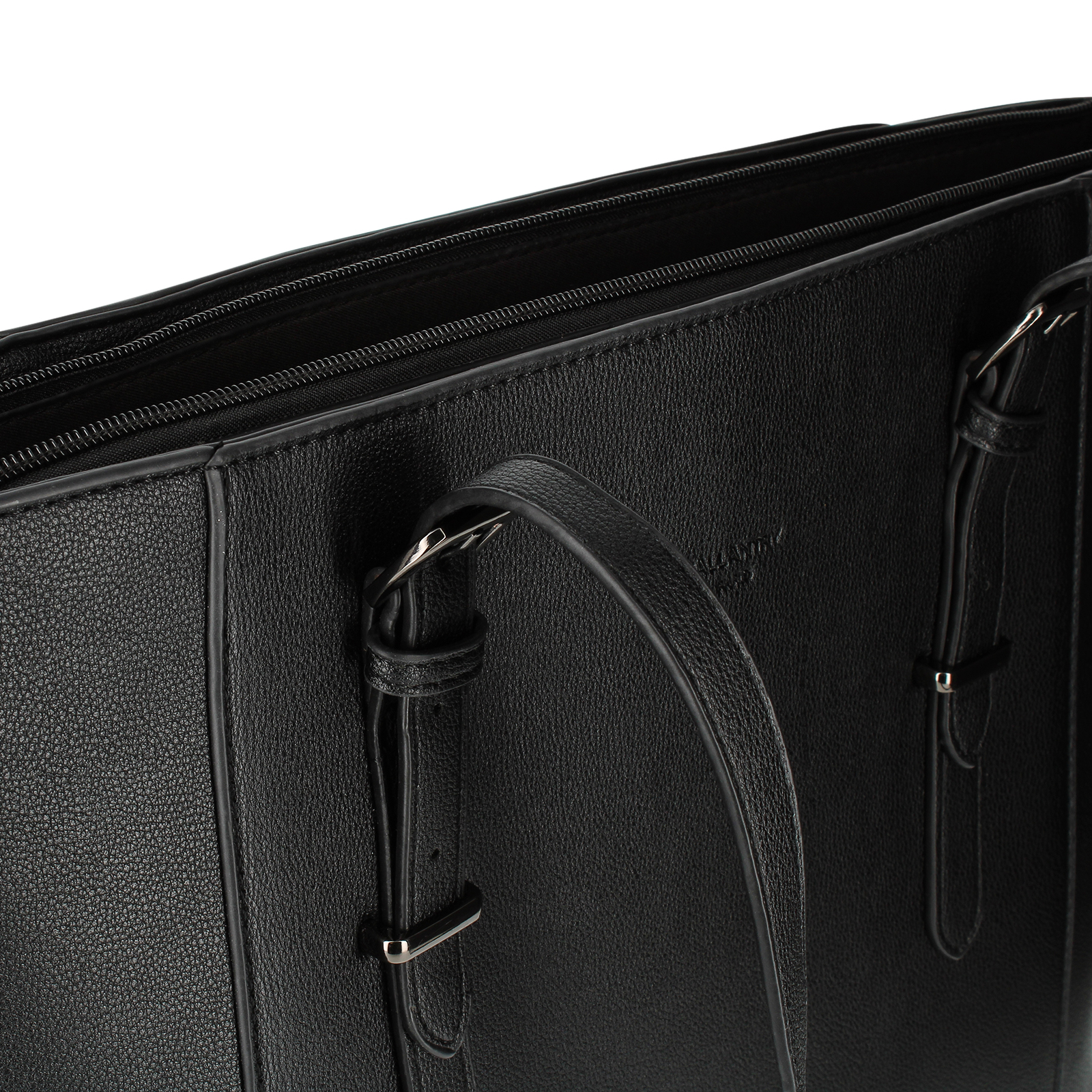 Primer plano de un bolso tote de cuero negro con cremallera abierta. Son visibles el asa y las correas. Fondo blanco.