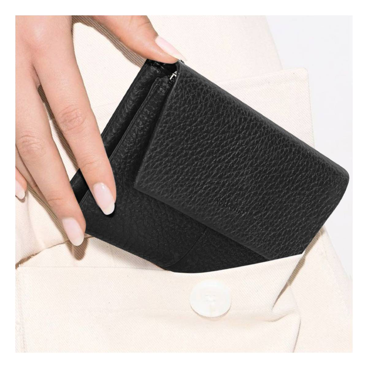 Eine Hand hält eine schwarze Ledergeldbörse, die sich teilweise in einer Tasche befindet. Die Tasche ist Teil heller Kleidung. Ein Knopf ist sichtbar.