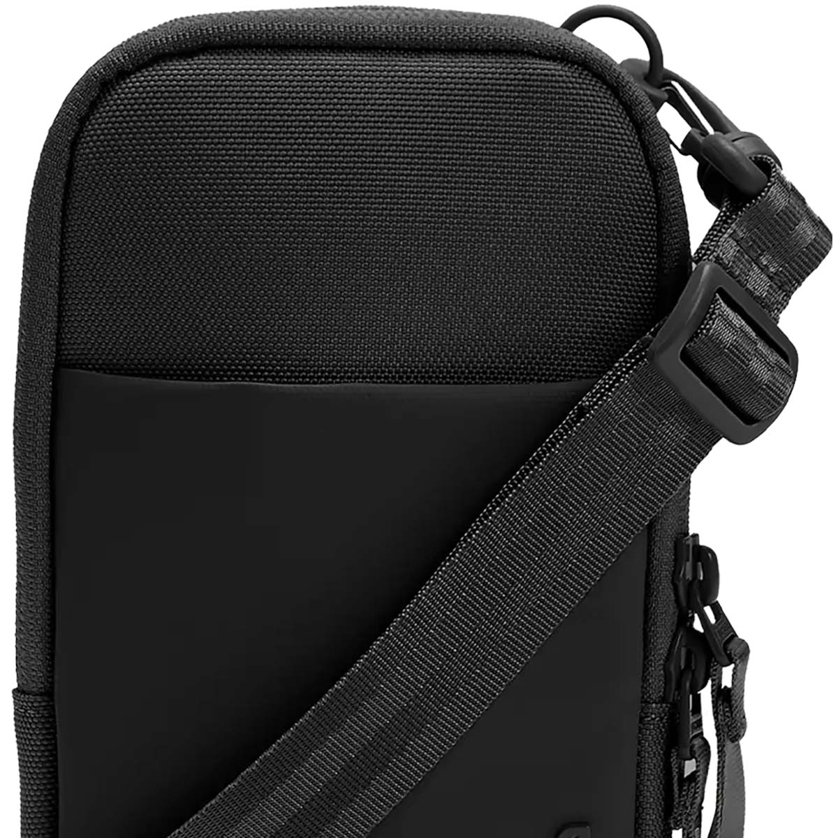 Primo piano di una borsa a tracolla nera con cinturino, clip e fibbia. La borsa ha una parte superiore strutturata e un fondo liscio.
