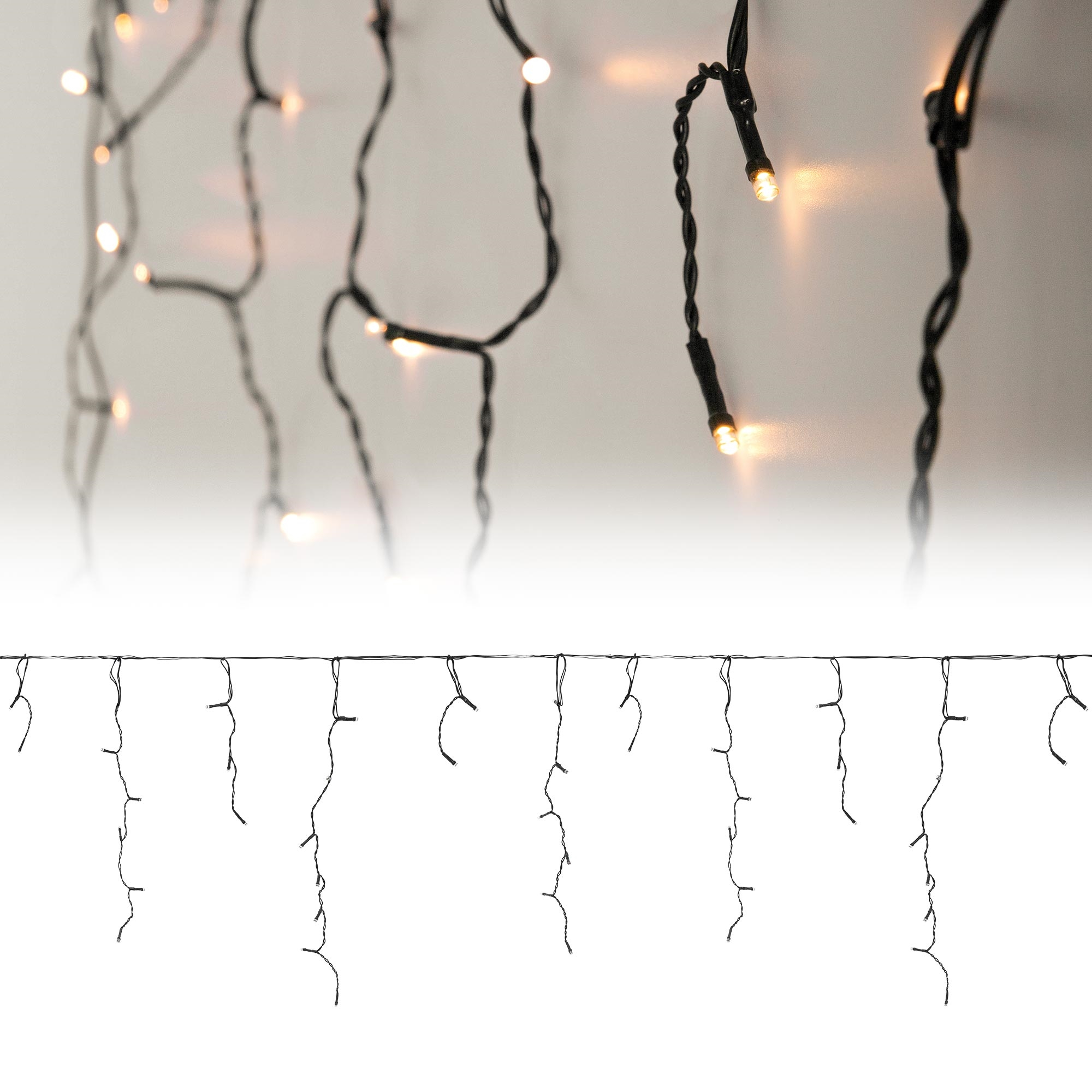 Lichterketten mit kleinen, warmweißen Glühbirnen hängen vor hellem Hintergrund. Schwarze Drähte halten die Lichter.