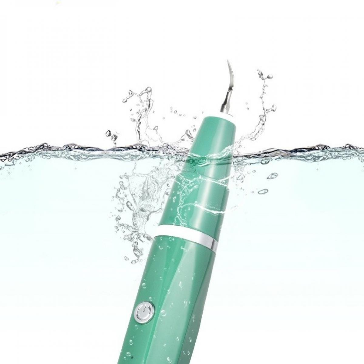 Ein grüner Zahnsteinentferner in Wasser getaucht, wobei Wasser um ihn herum spritzt. Der Scaler hat eine silberne Spitze und einen Knopf.