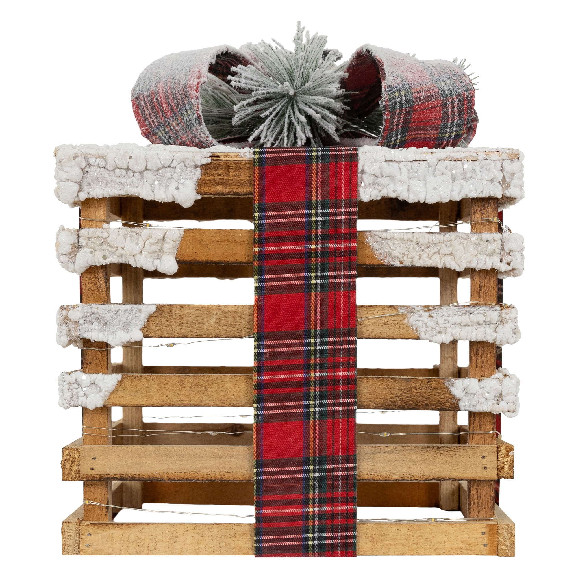 Eine Holzkiste mit Schnee, rotem Karoband und einer Schleife oben. Die Kiste hat Lichterketten.