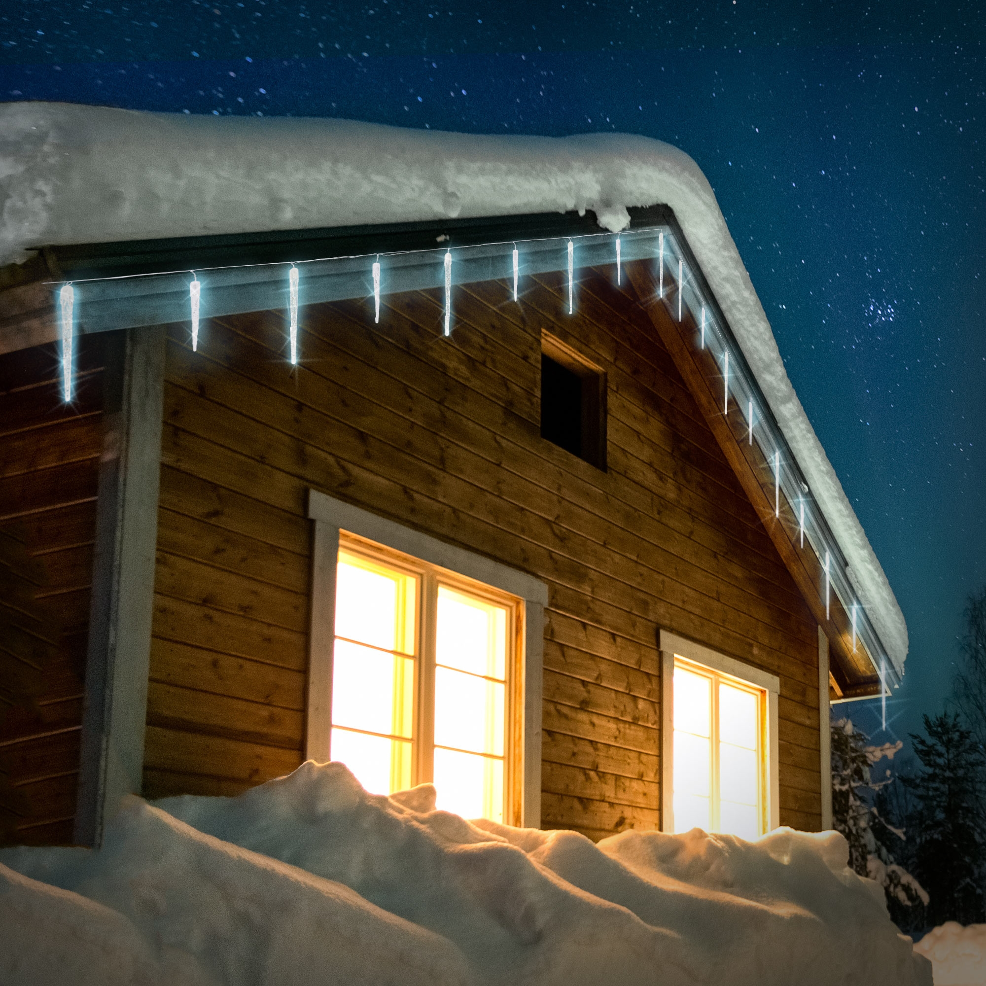 Holzhütte bei Nacht. Schneebedecktes Dach, Eiszapfen, beleuchtete Fenster und Sternenhimmel.