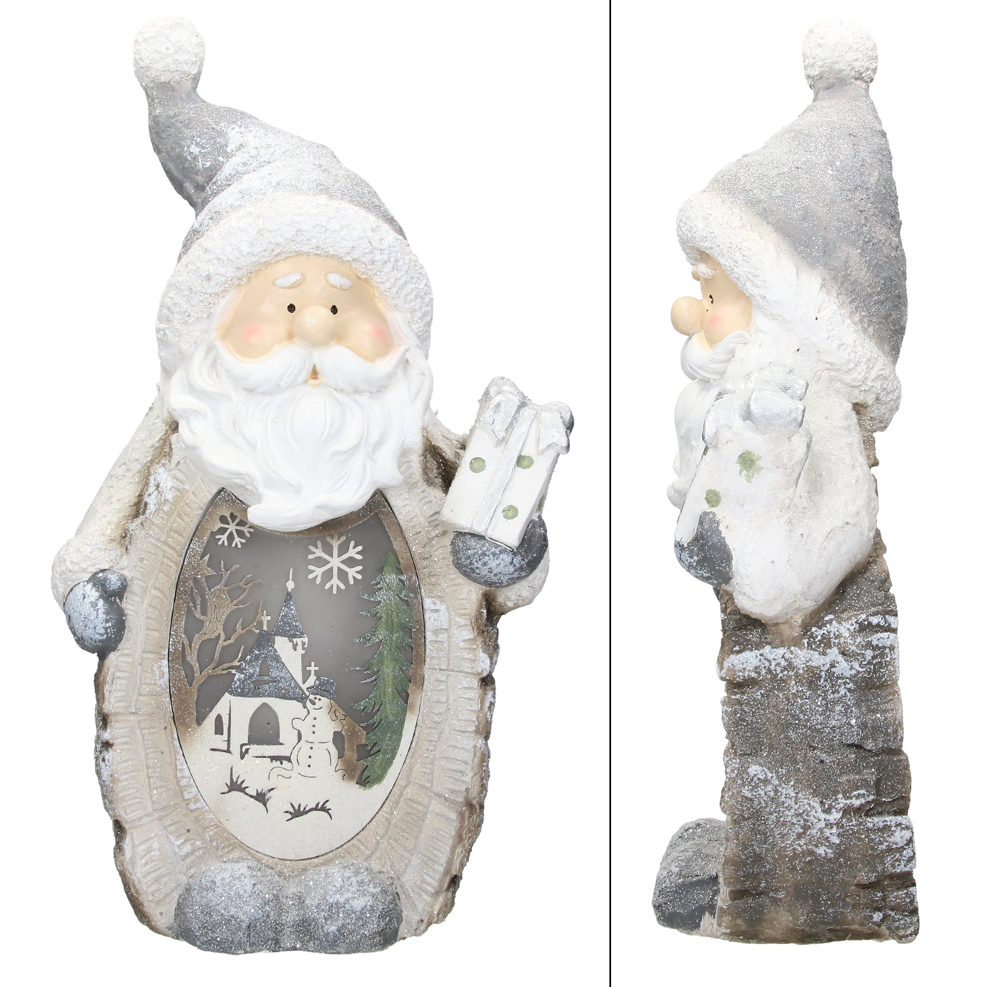 Statue des Weihnachtsmanns mit einem Geschenk. Es hat eine beleuchtete Szene einer Kirche und eines Schneemanns.