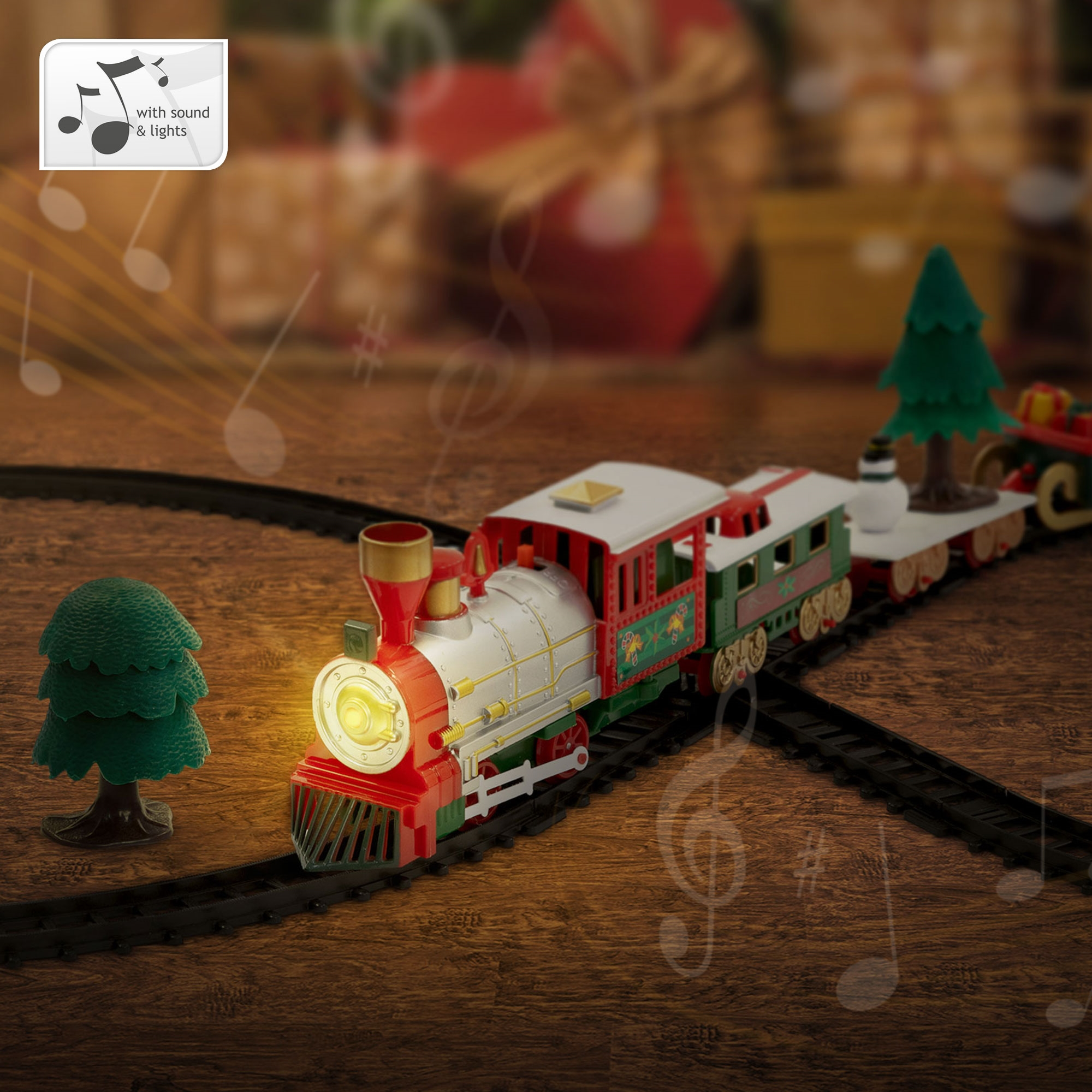 Ein Spielzeugzug mit Weihnachtsbaum und Wagen auf einer Strecke mit Noten. Der Zug hat Lichter.