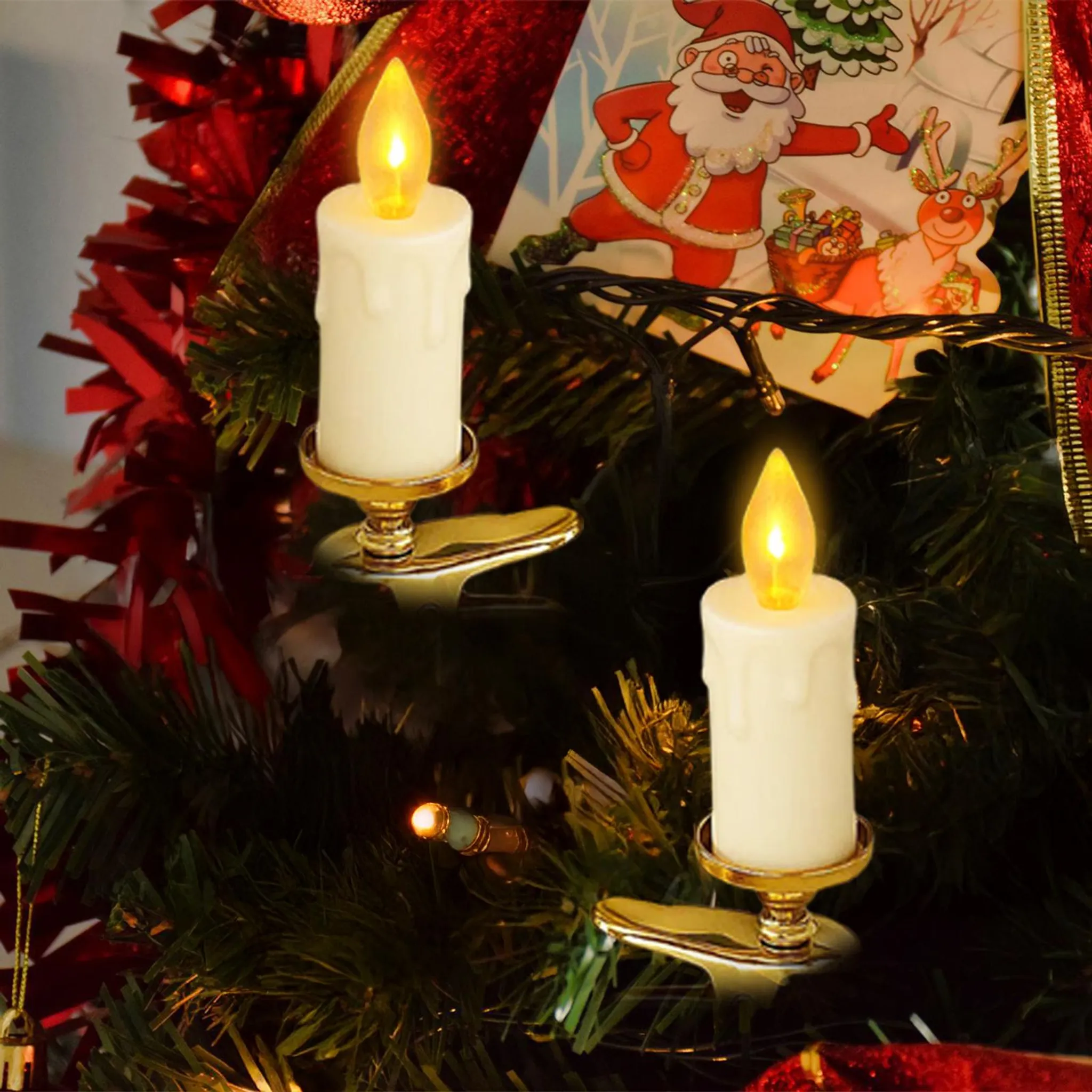 Zwei Kerzenlichter an einem Weihnachtsbaum. Weihnachtsmann- und Rentierkarte im Hintergrund, roter Lametta und grüne Zweige.