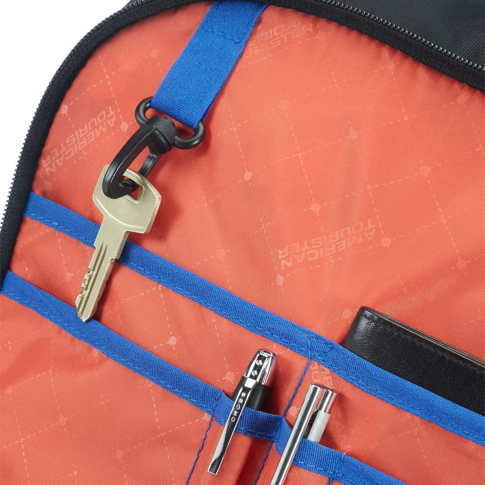 Innentasche: Schlüssel, Stifte, Geldbörse. Orangenes Innere mit blauen Riemen und schwarzem Reißverschluss. American Tourister Logo.