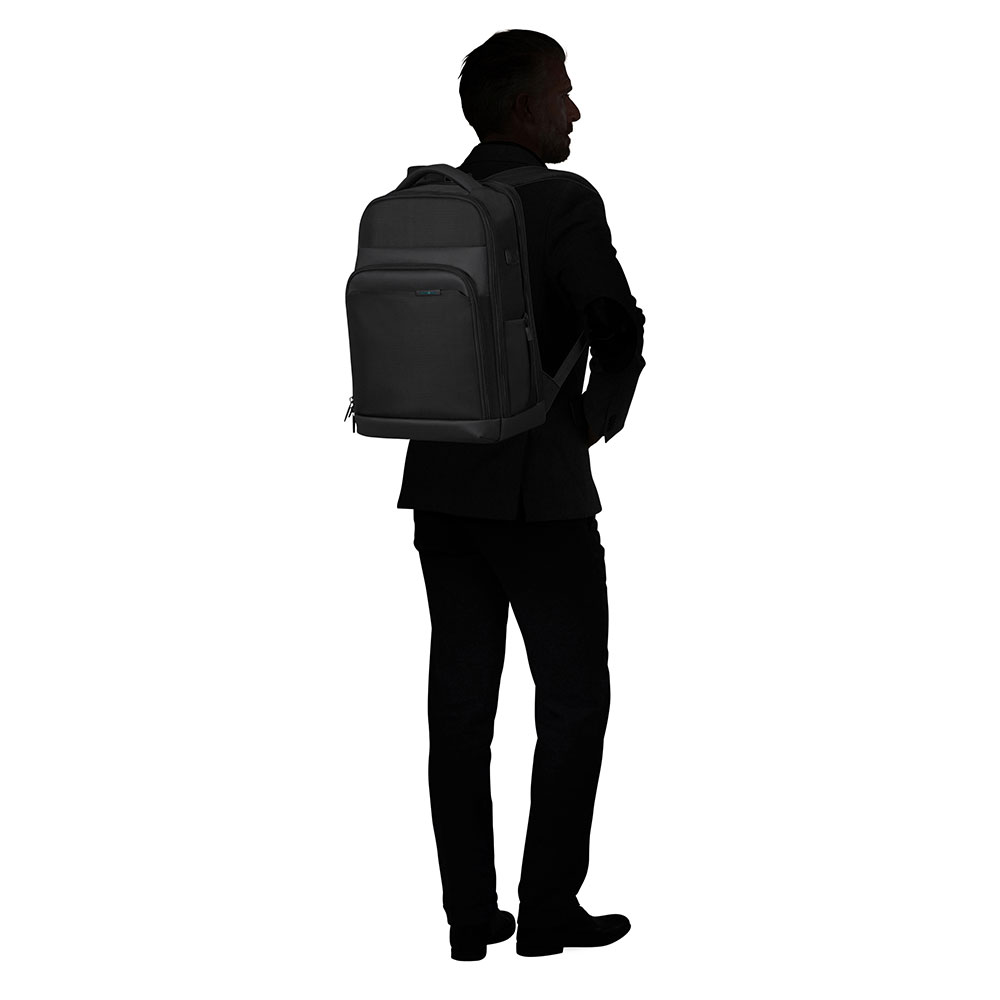 Ein Mann in schwarzem Anzug und Rucksack ist von hinten zu sehen. Der Rucksack ist schwarz. Der Hintergrund ist weiß.