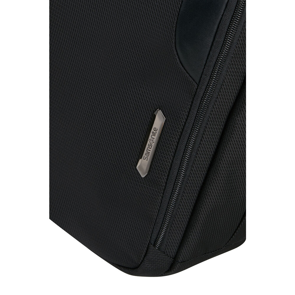 Primo piano di una borsa Samsonite nera. Visibile un'etichetta argentata con il marchio. Sono visibili anche la cerniera e il tessuto.
