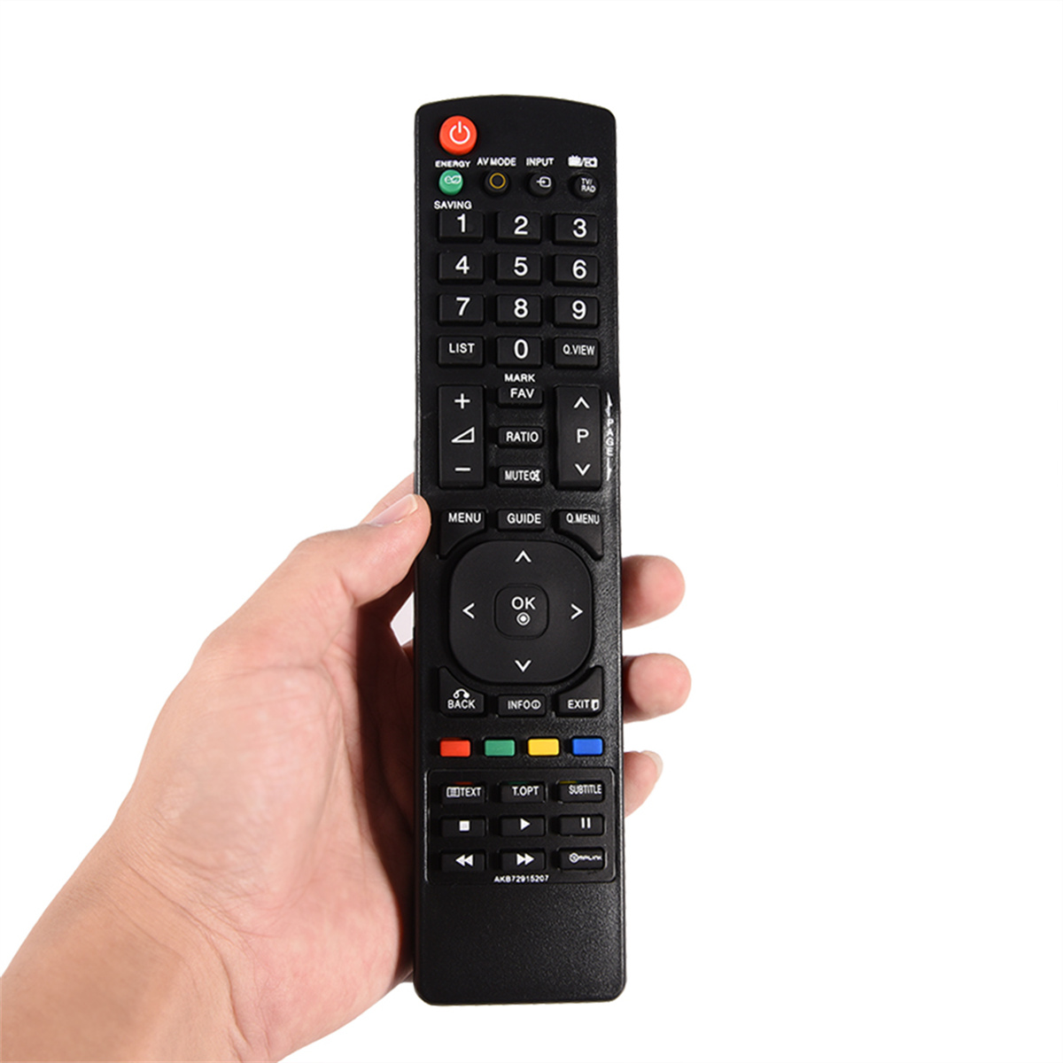 Eine Hand hält eine schwarze TV-Fernbedienung mit vielen Knöpfen. Zahlen, Lautstärke- und Kanalregler sind sichtbar.