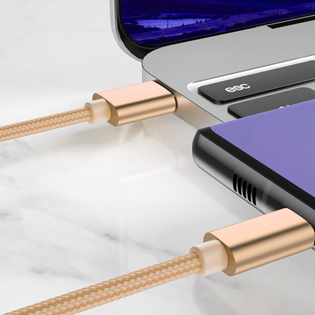 Ein Telefon und ein Laptop sind durch goldene Ladekabel verbunden. Das Telefon ist lila und der Laptop ist silber.